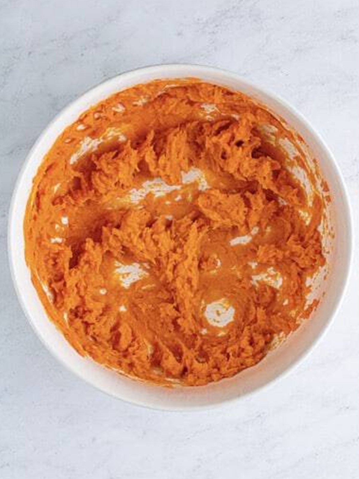 Cooked sweet potatoes whipped smooth in a bowl for sweet potato pie.