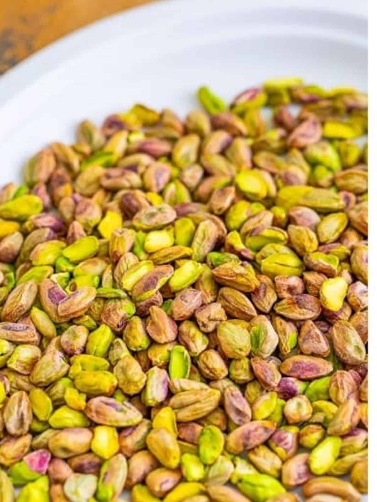Shelled raw pistachios in a bowl for homemade pistachio cream.