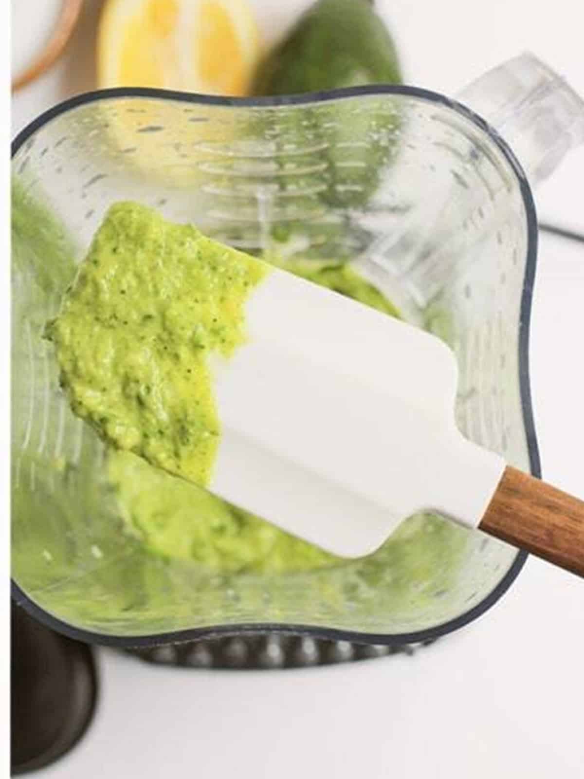 Scraping the creamy green goddess dressing from the blender.