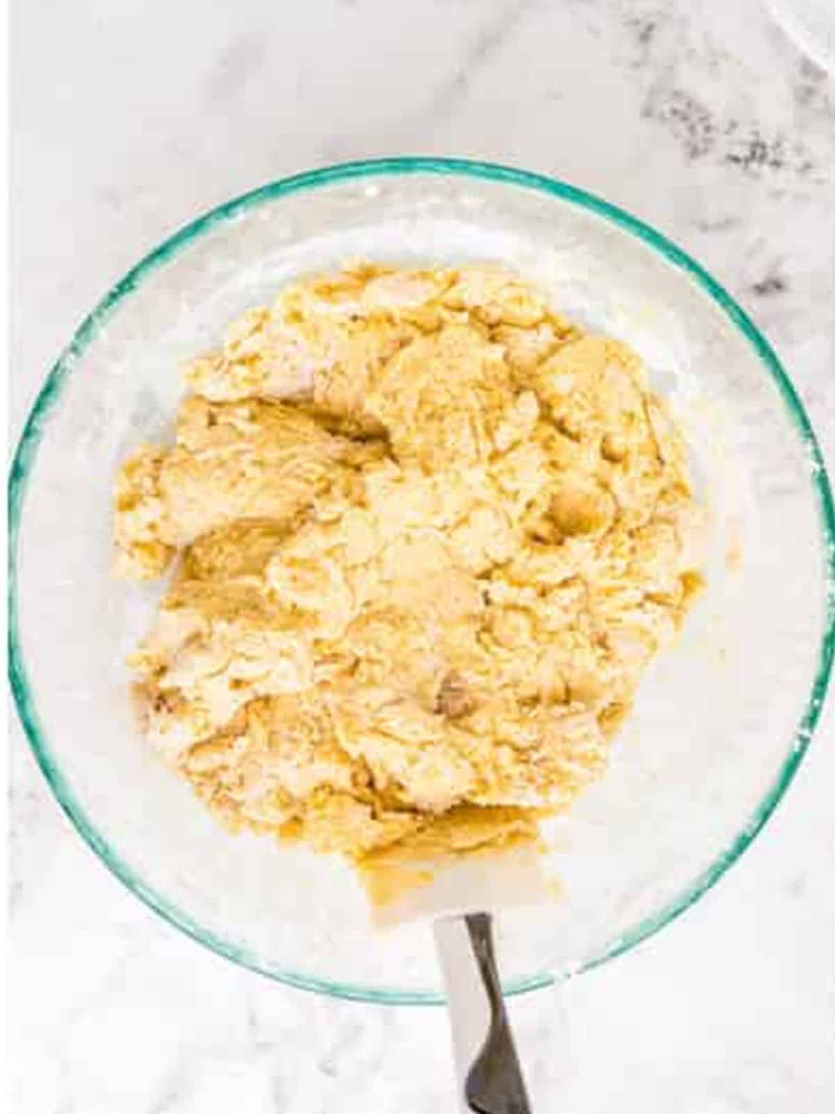 Munchkin dough combined in a glass mixing bowl.