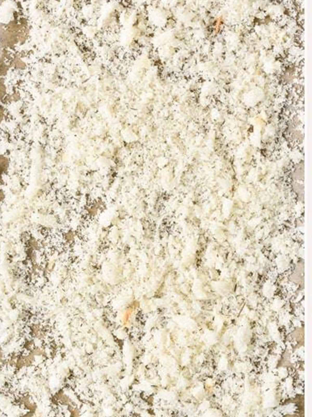 Homemade panko crumbs spread on a parchment lined baking sheet.
