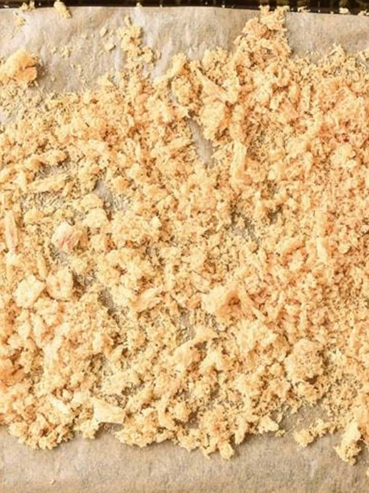 Golden toasted homemade panko bread crumbs on a baking sheet.