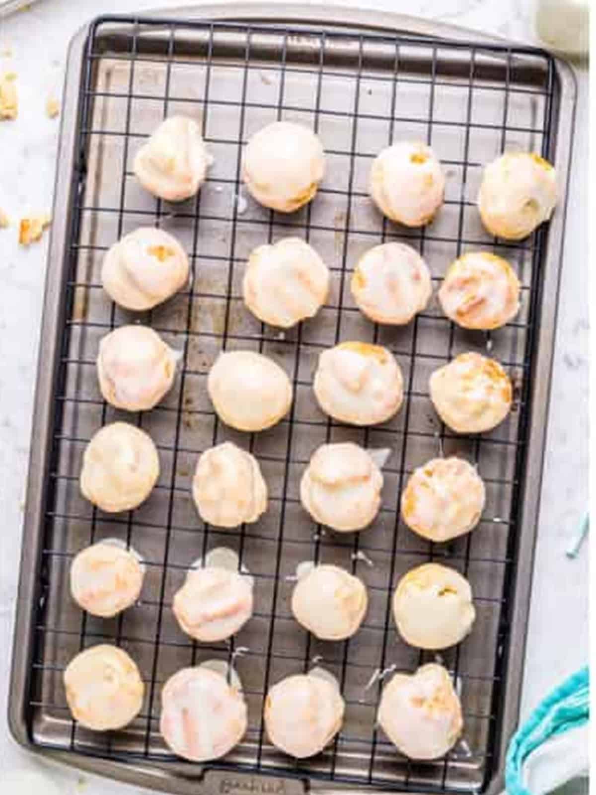 Glazed munchkins set on a wire rack.