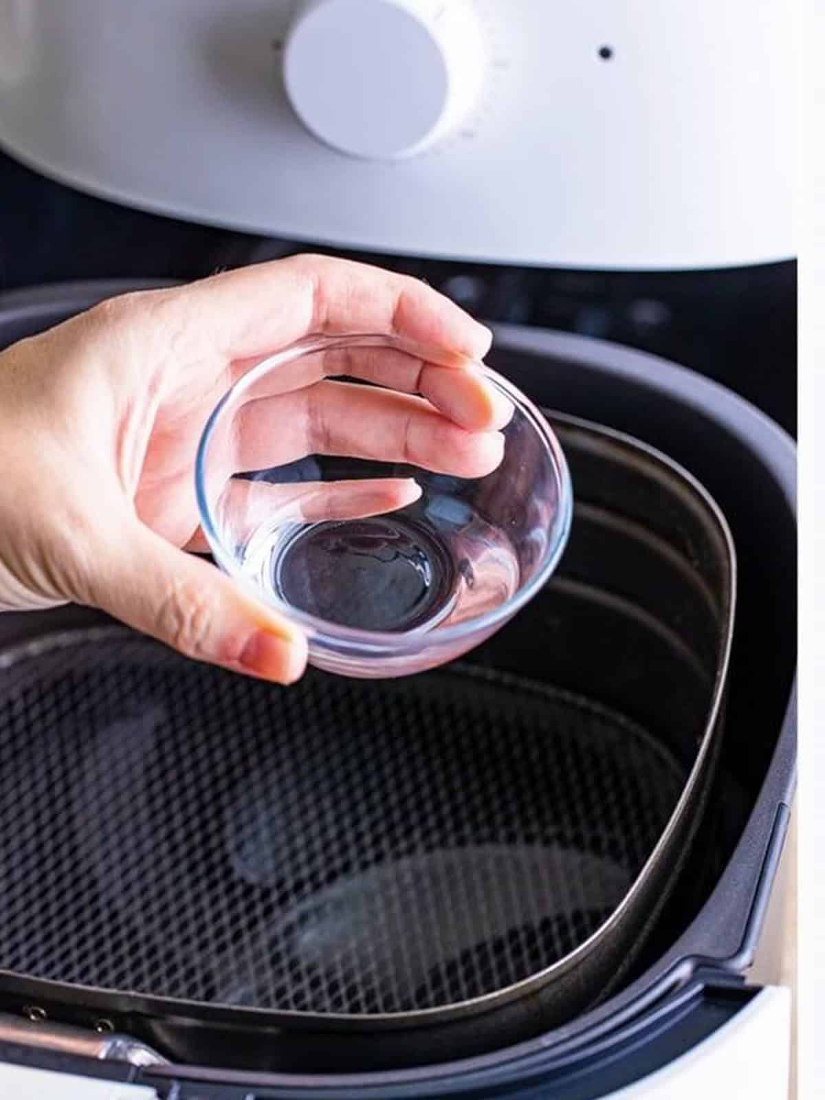 Adding water to the air fryer basket before cooking the ribeye to reduce smoking.