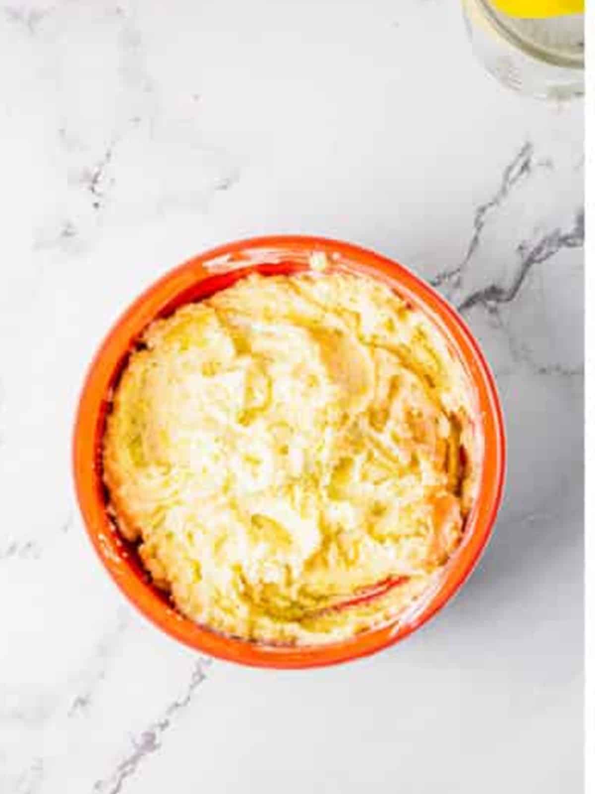 Potato insides mashed with sour cream, butter, and parmesan in a bowl.