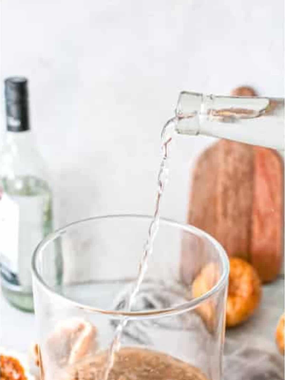 Pouring tequila into a pitcher for passion fruit margaritas.