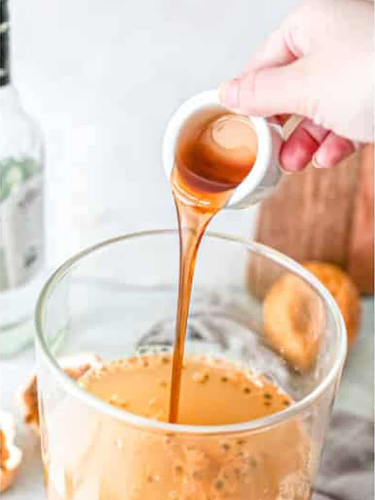 Pouring honey into the passion fruit margarita.