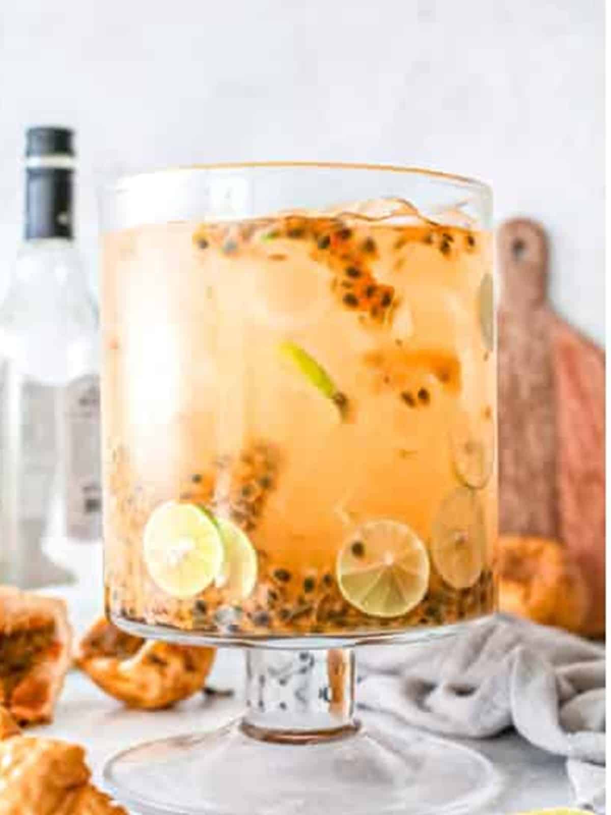 Passion fruit margarita pitcher filled with ice and lime slices.