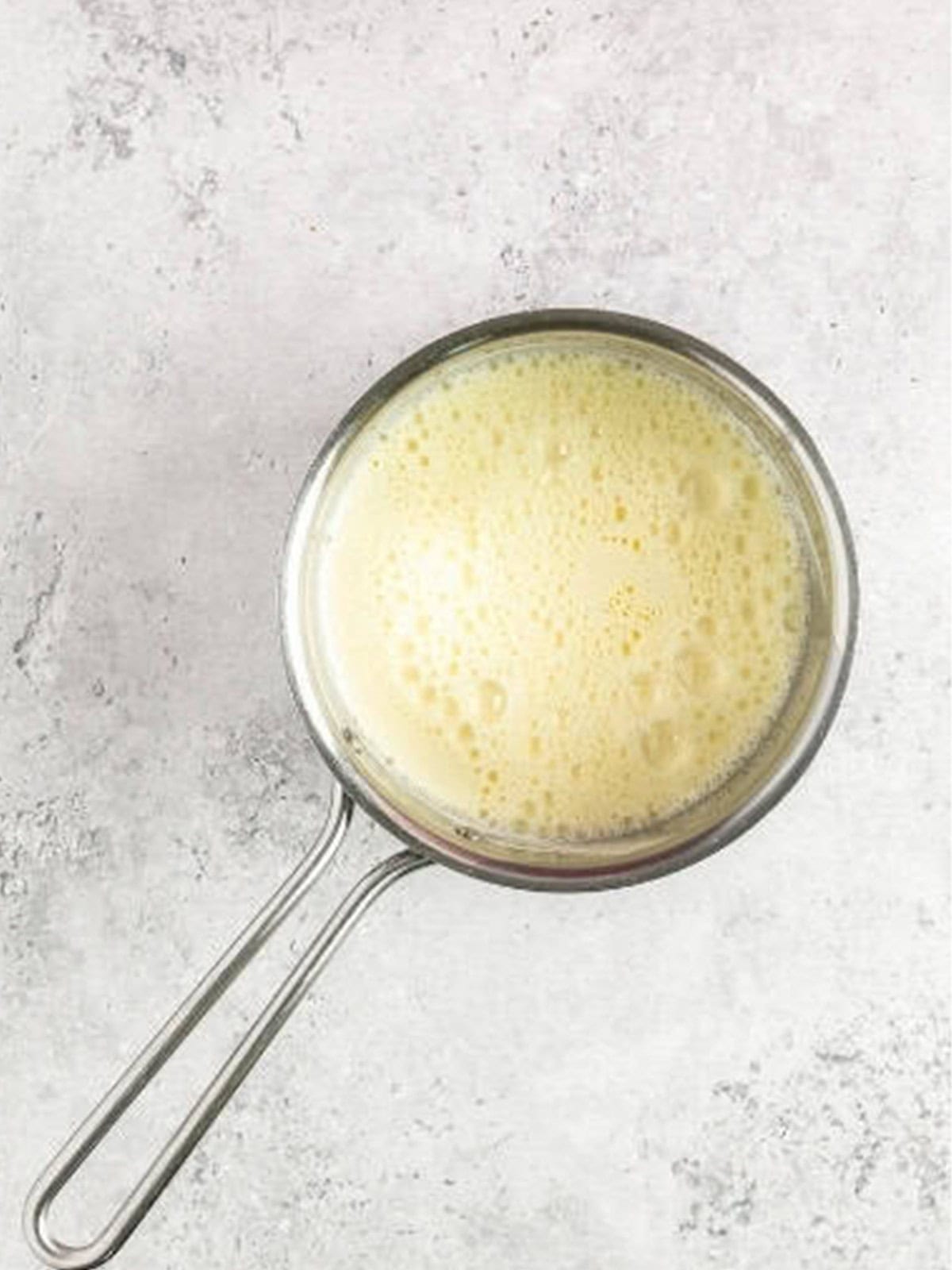 Cooking the pastry cream until thick in a saucepan.