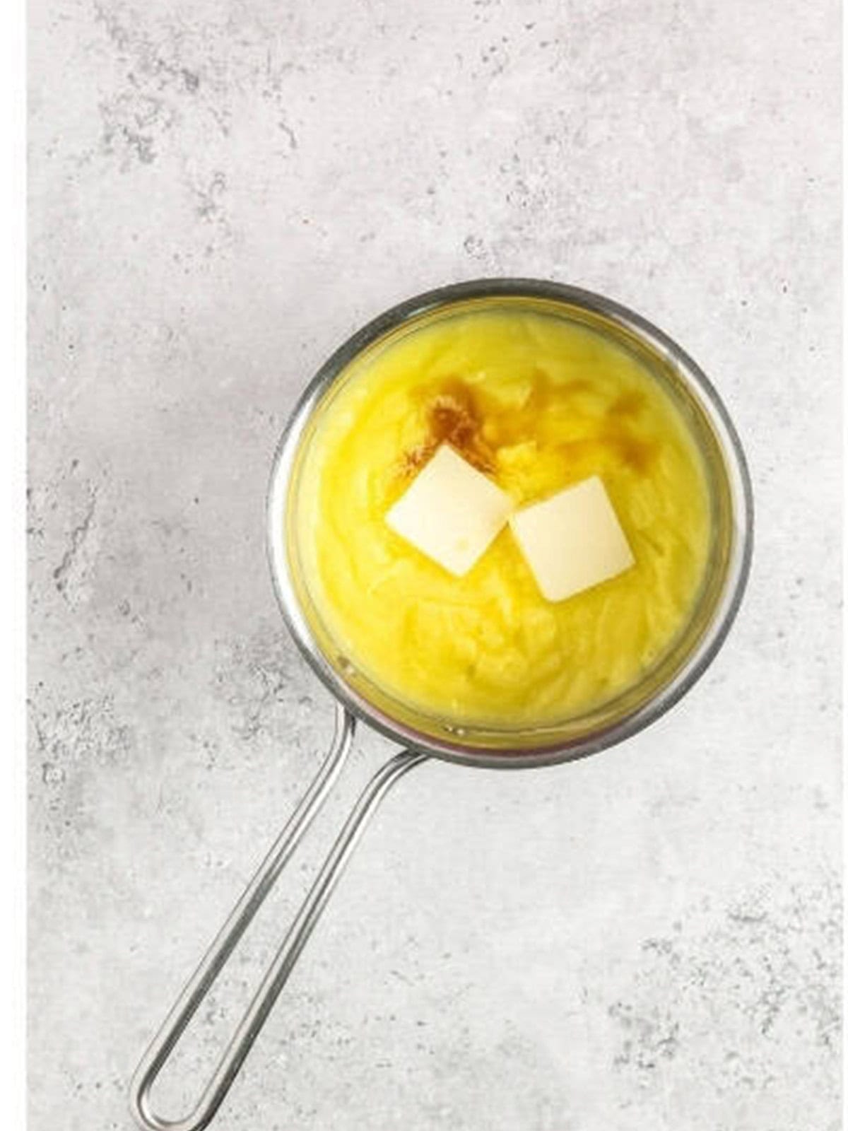 Stirring butter into the finished pastry cream.