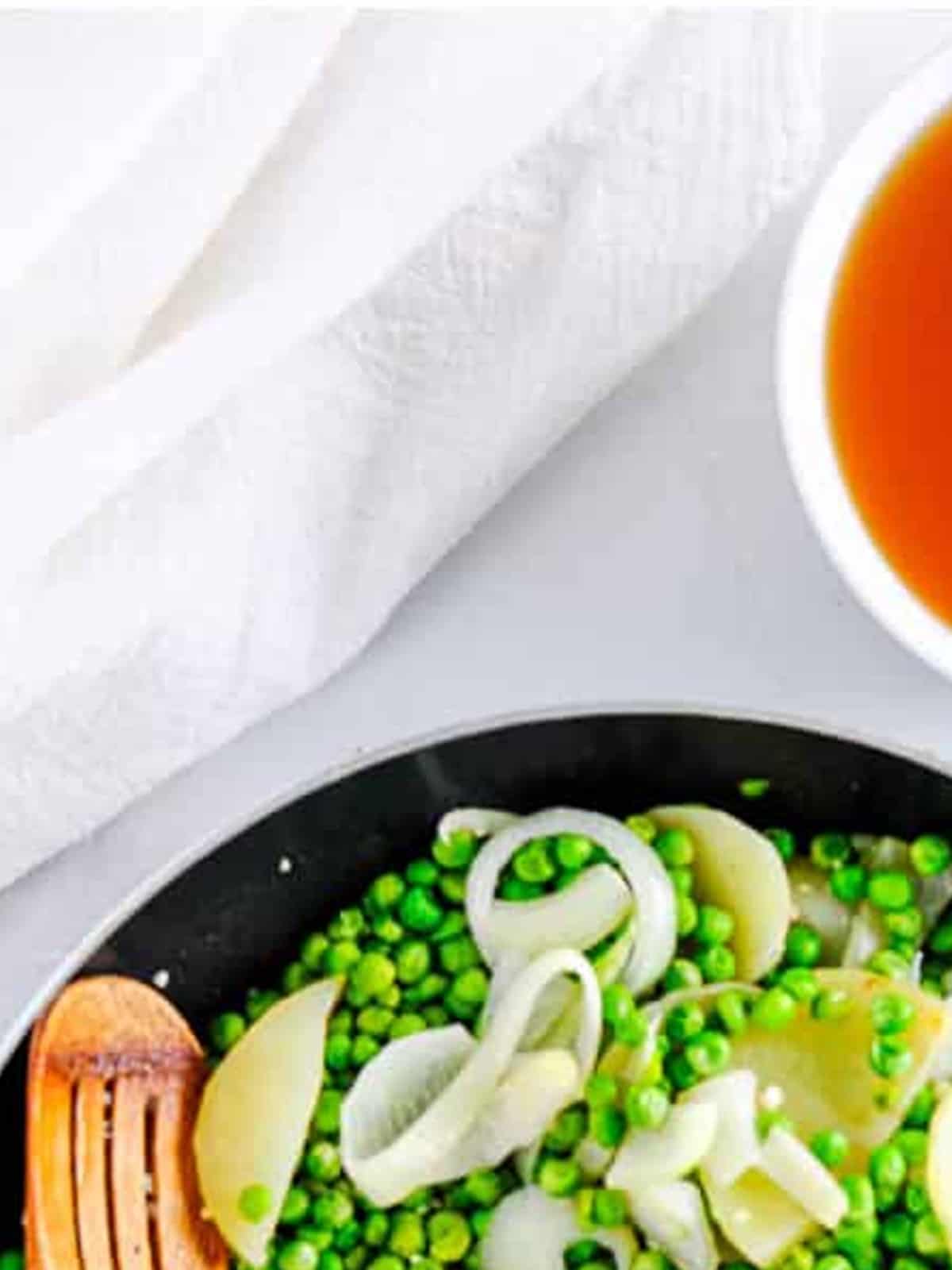 Peas, potatoes, onion, and garlic sauteing in a skillet for Pea Soup.