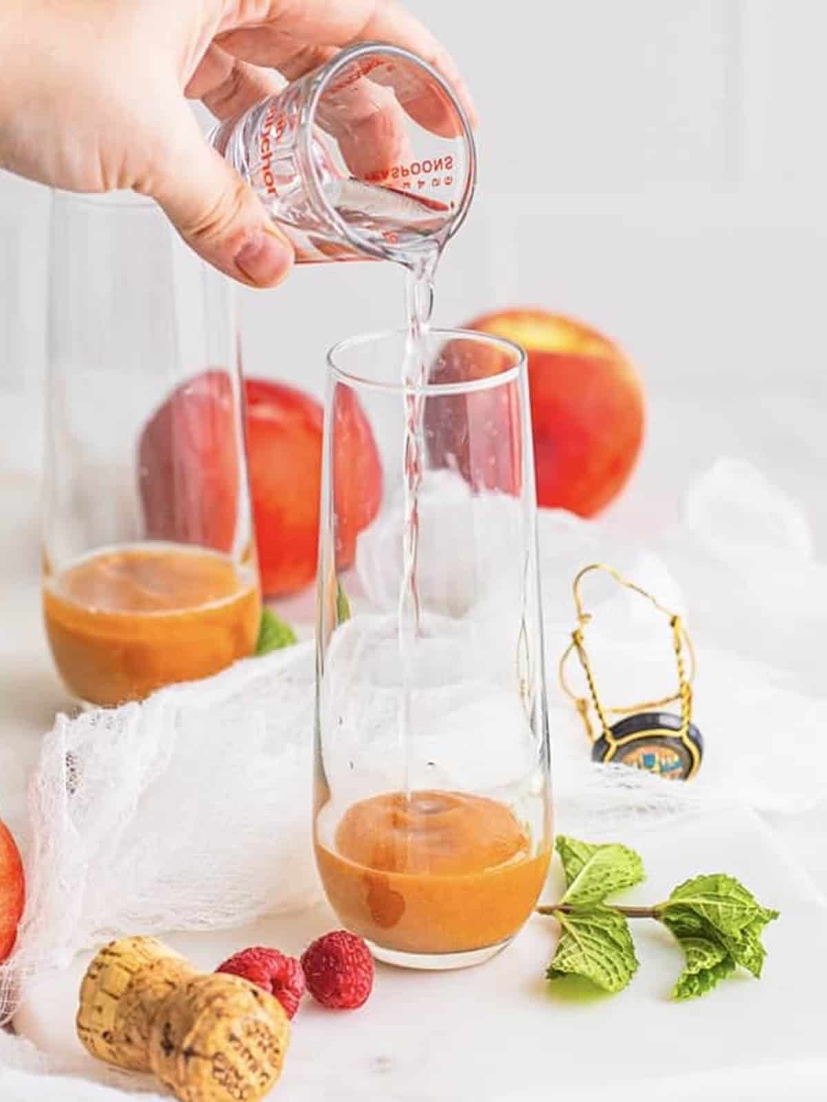 Peach puree and peach schnapps layered in the bottom of a champagne glass.