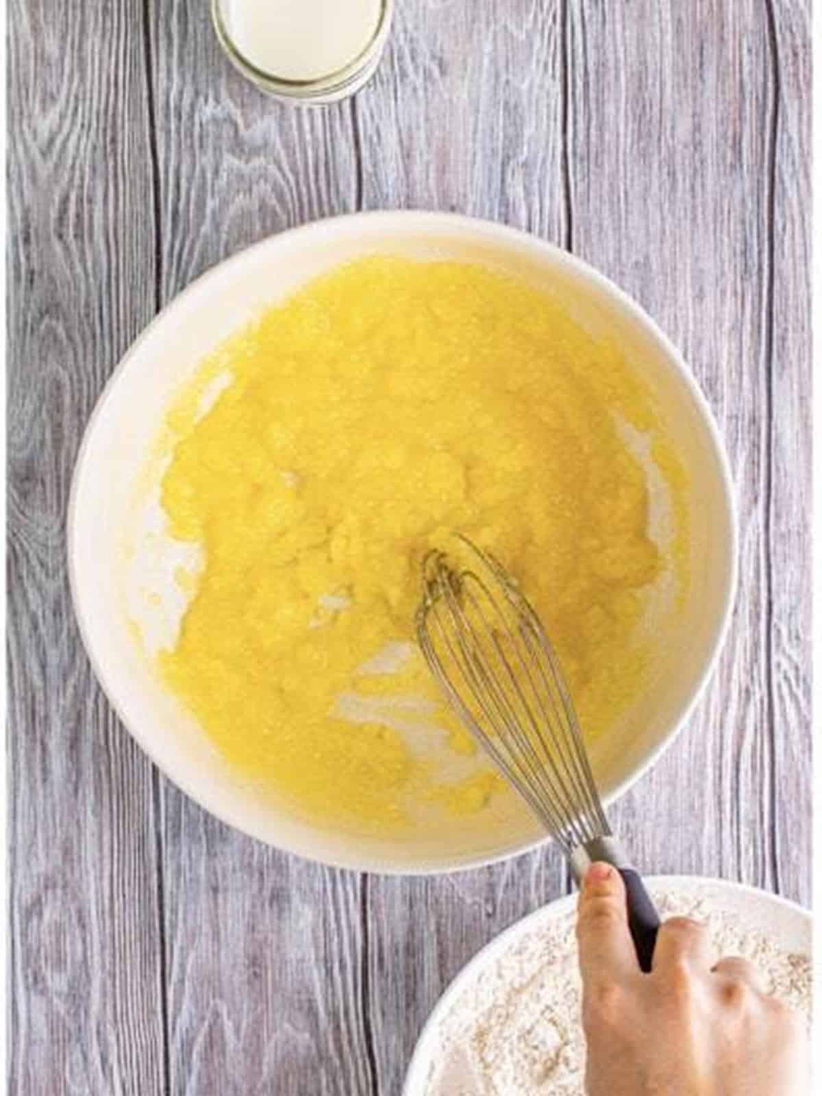 Sugar and melted butter whisked together in a bowl.