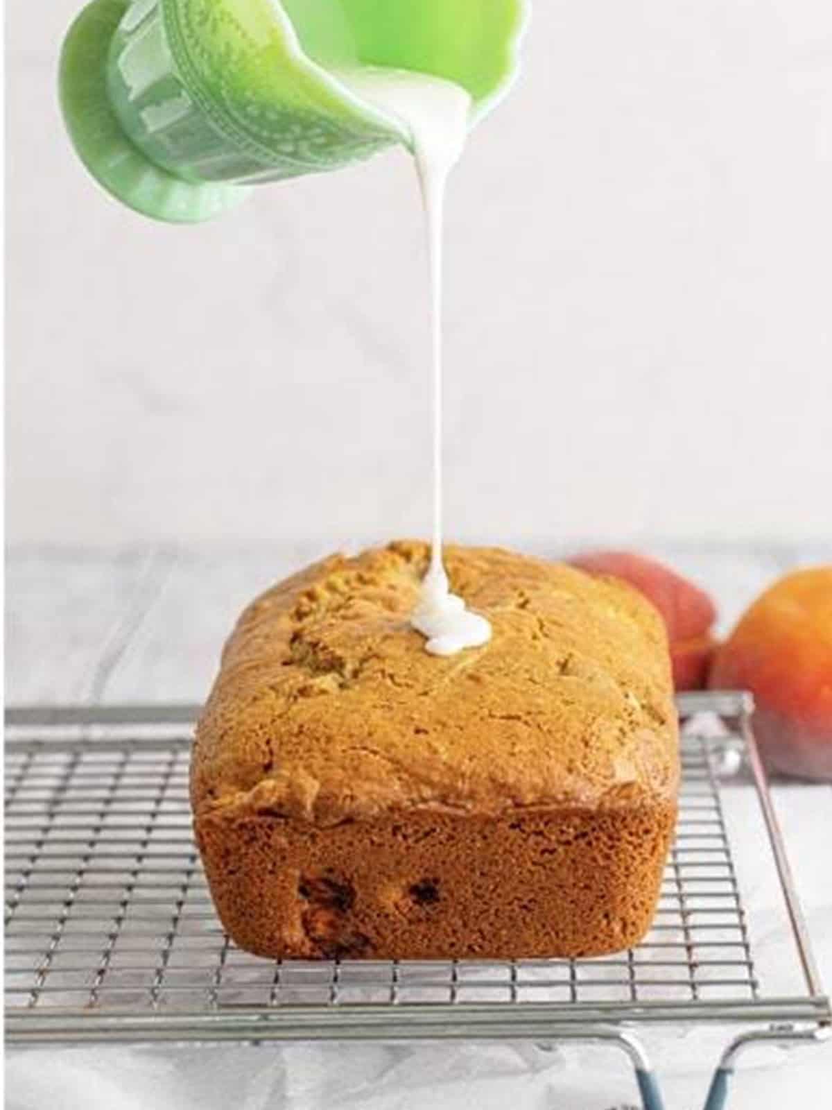 Vanilla glaze poured over the cooled peach bread loaf.