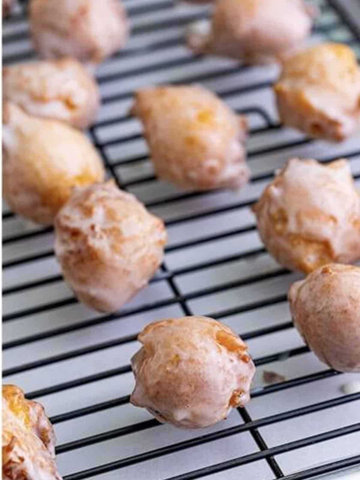 Glazed Peach Fritters cooling on a wire rack.