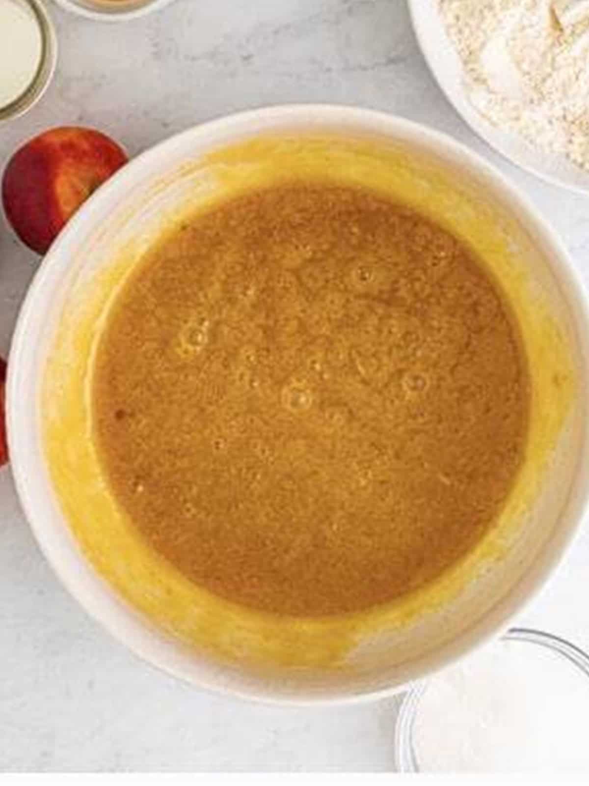 Oil, brown sugar, eggs, sour cream, and vanilla whisked smooth in a bowl.