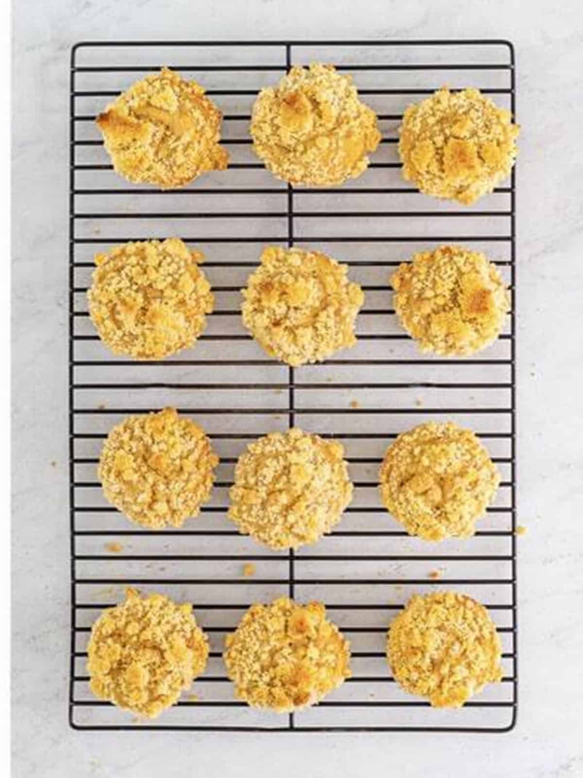 Golden baked peach muffins cooling on a wire rack.