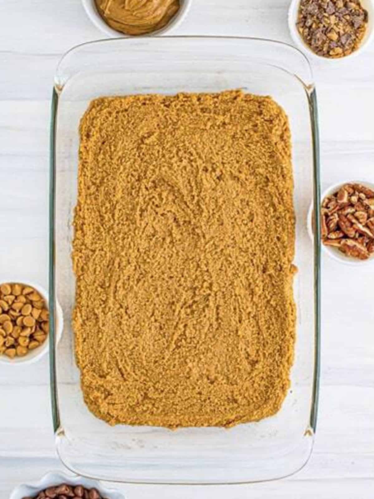 The peanut butter graham cracker base pressed evenly into a glass baking dish.