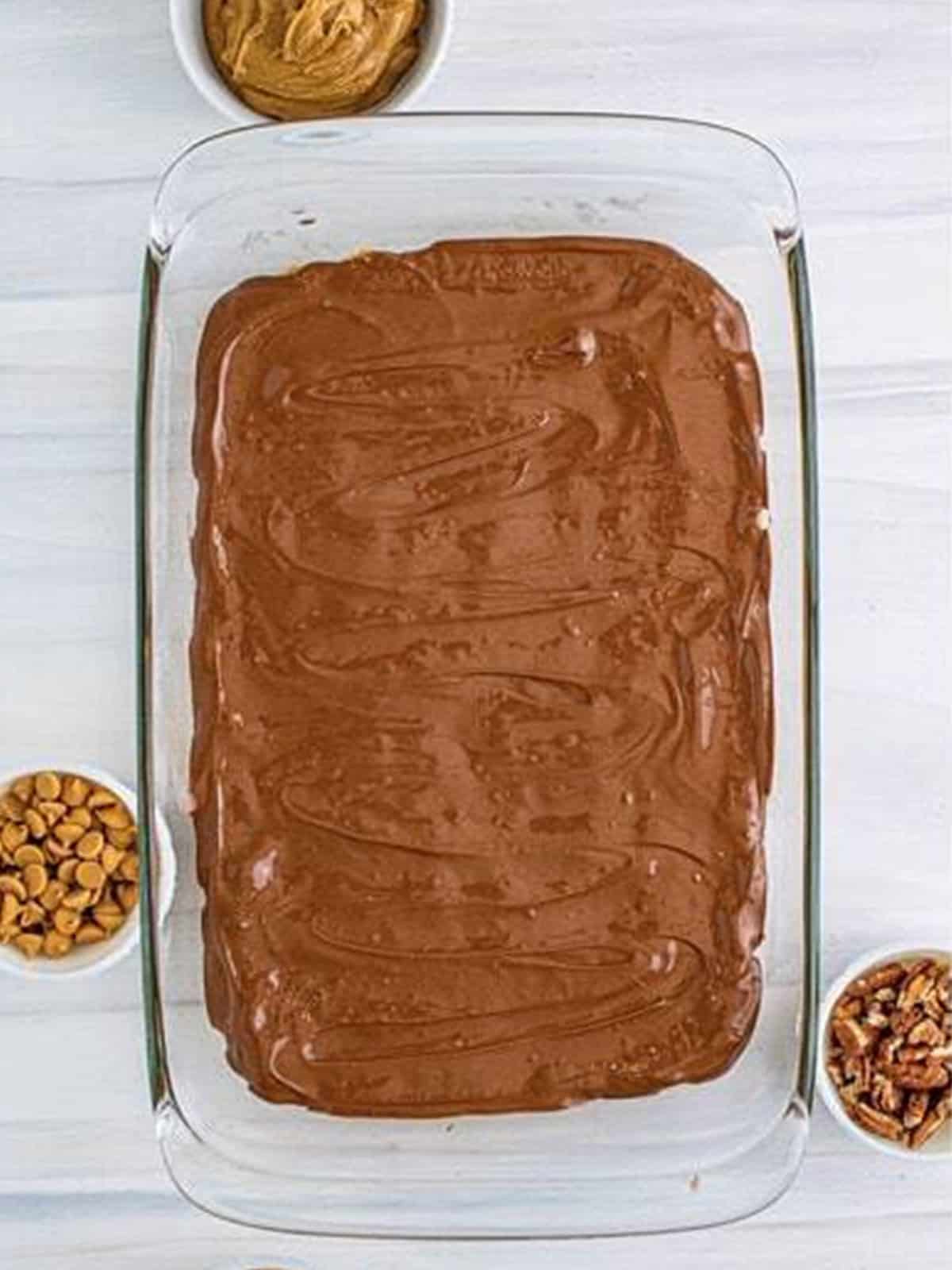 Melted chocolate spread over the peanut butter base in a baking dish.