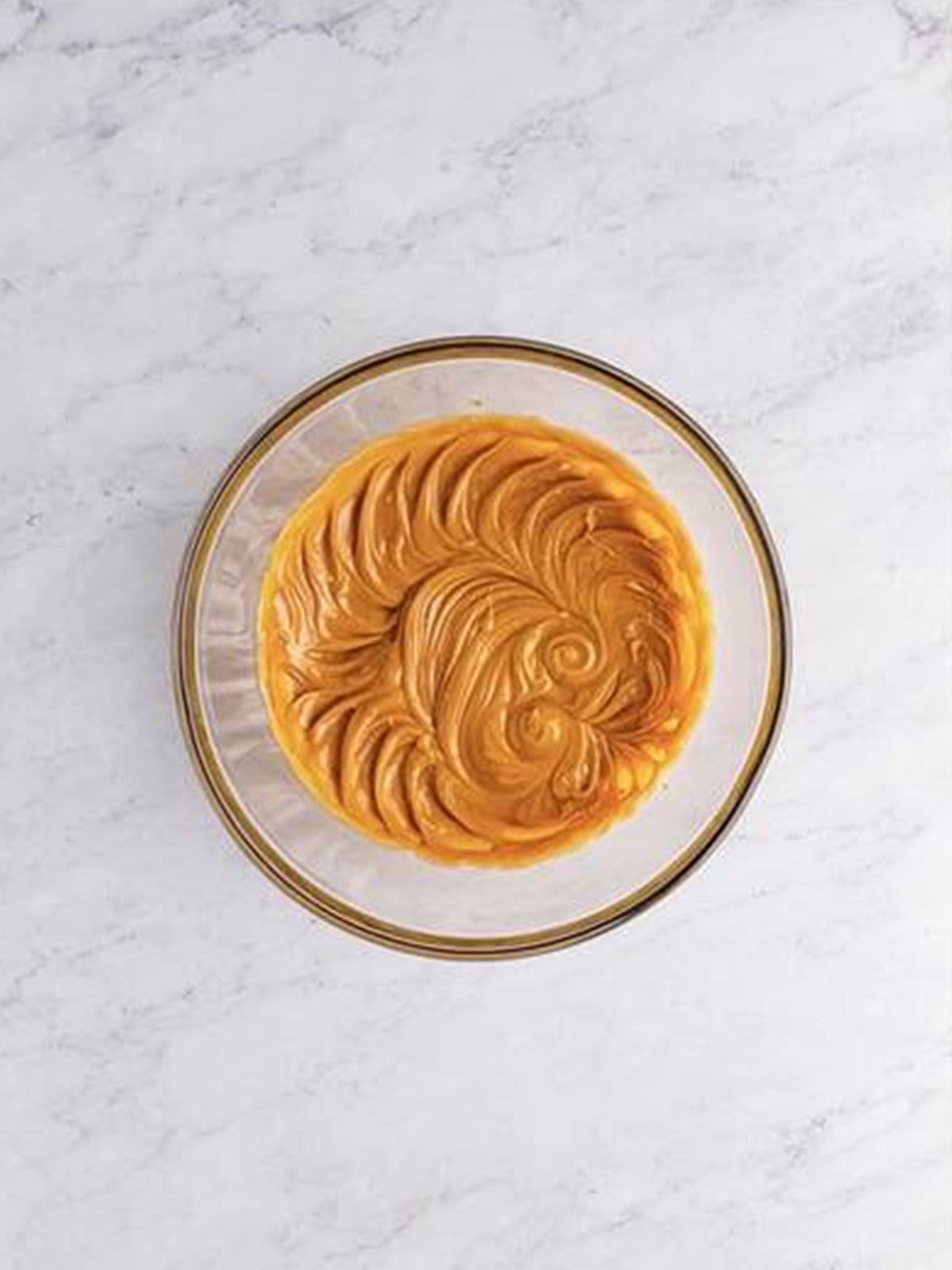 Creamy peanut butter and butter in a bowl for peanut butter frosting.
