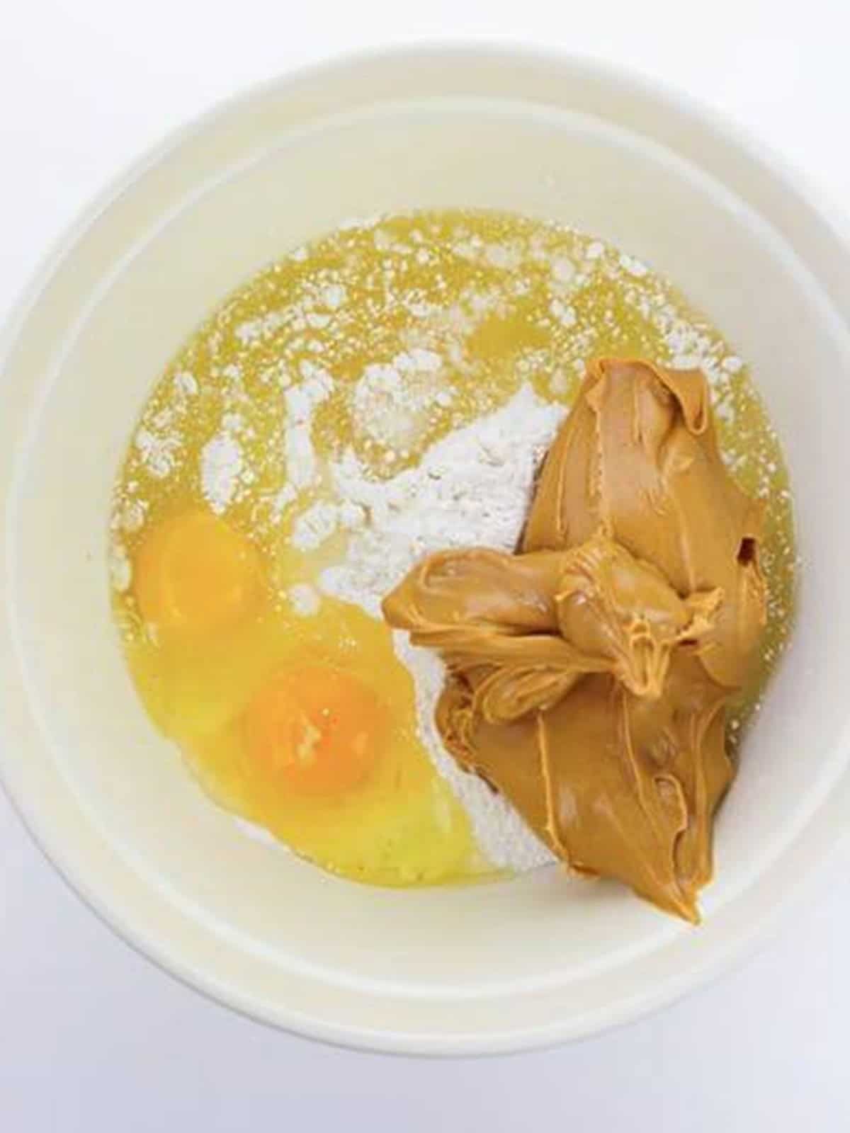 Cake mix, peanut butter, eggs, and oil in a bowl for peanut butter cake mix cookies.