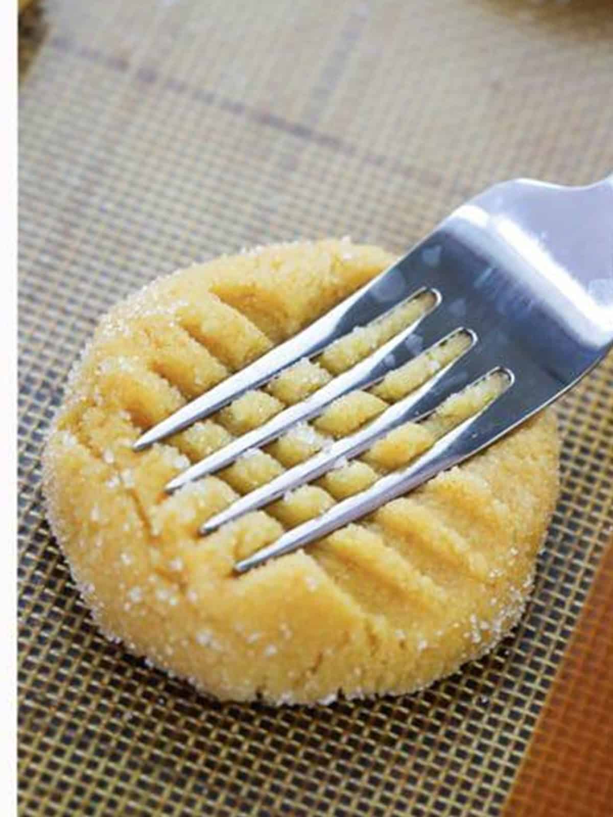 A crosshatch pattern pressed into a peanut butter cake mix cookie.