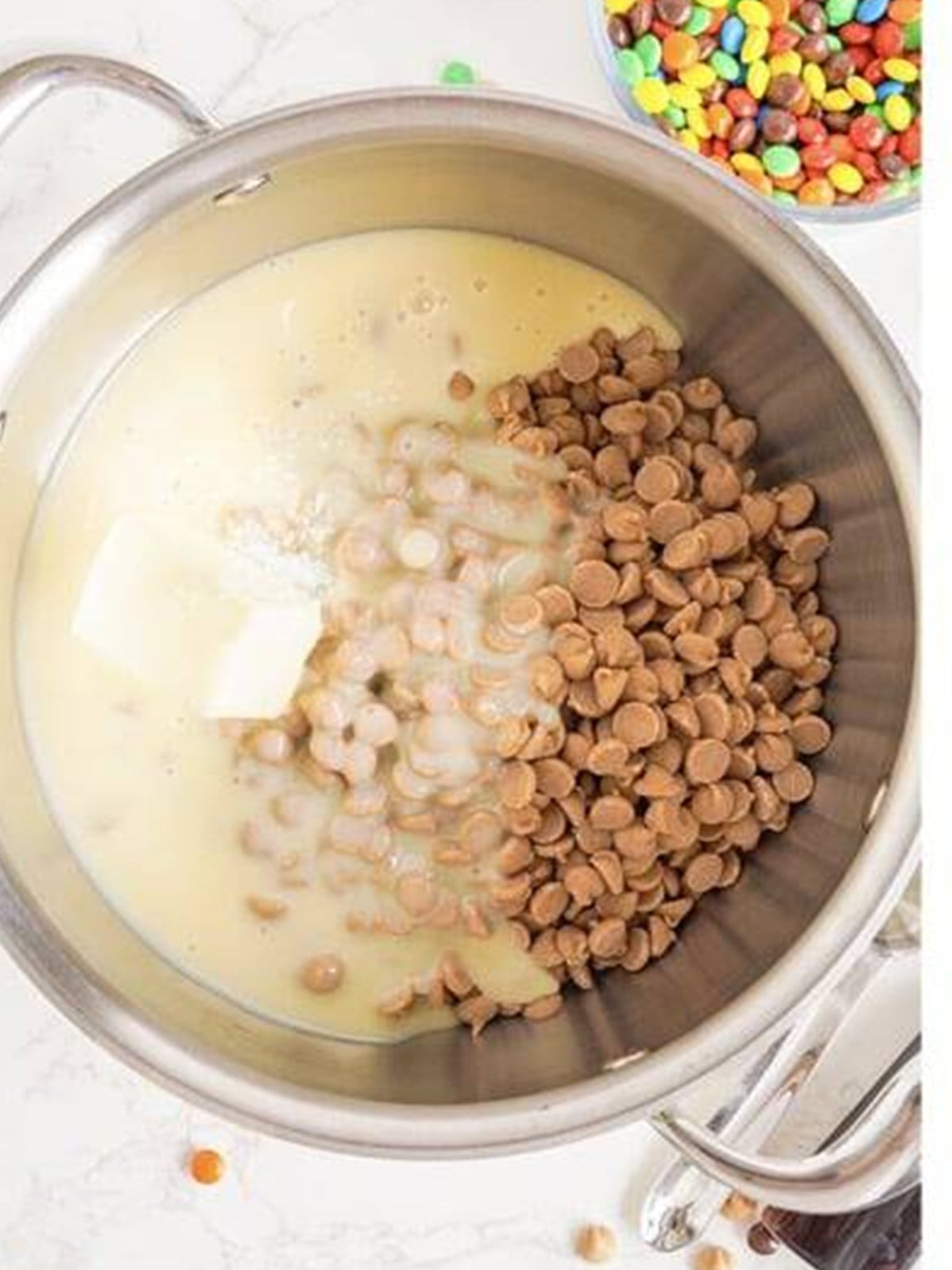 Peanut butter chips, butter, and sweetened condensed milk in a saucepan for peanut butter fudge.