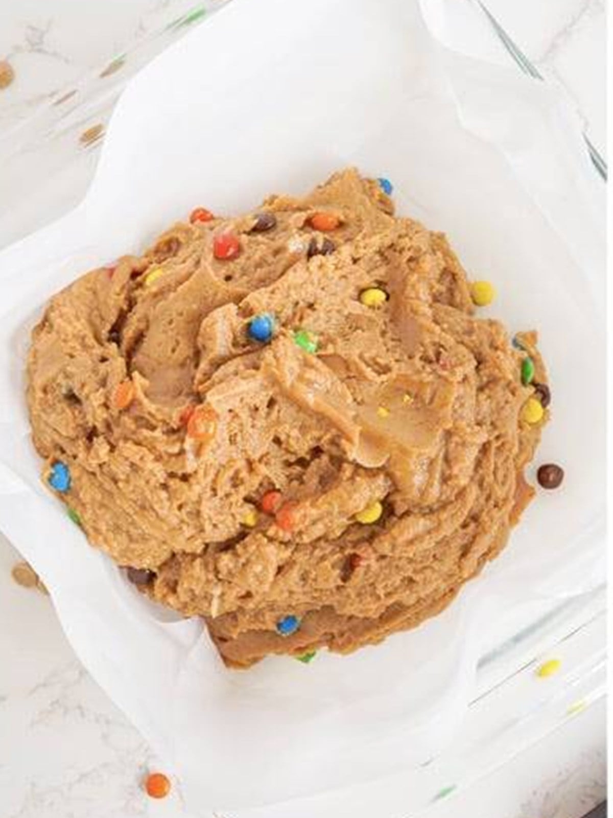 Pressing the peanut butter fudge into a parchment-lined pan.