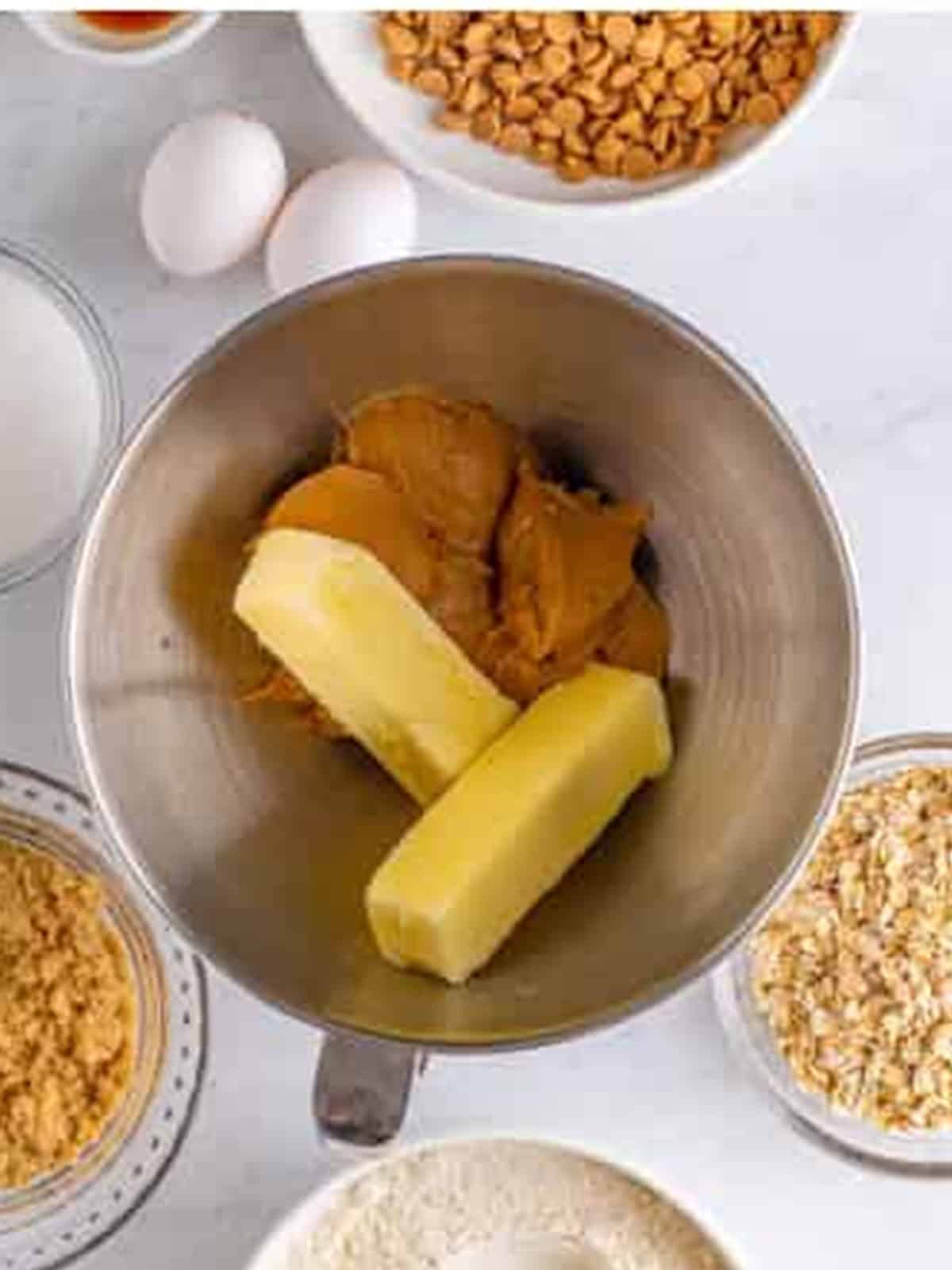 Creamy peanut butter and butter in a stand mixer bowl for peanut butter oatmeal cookies.
