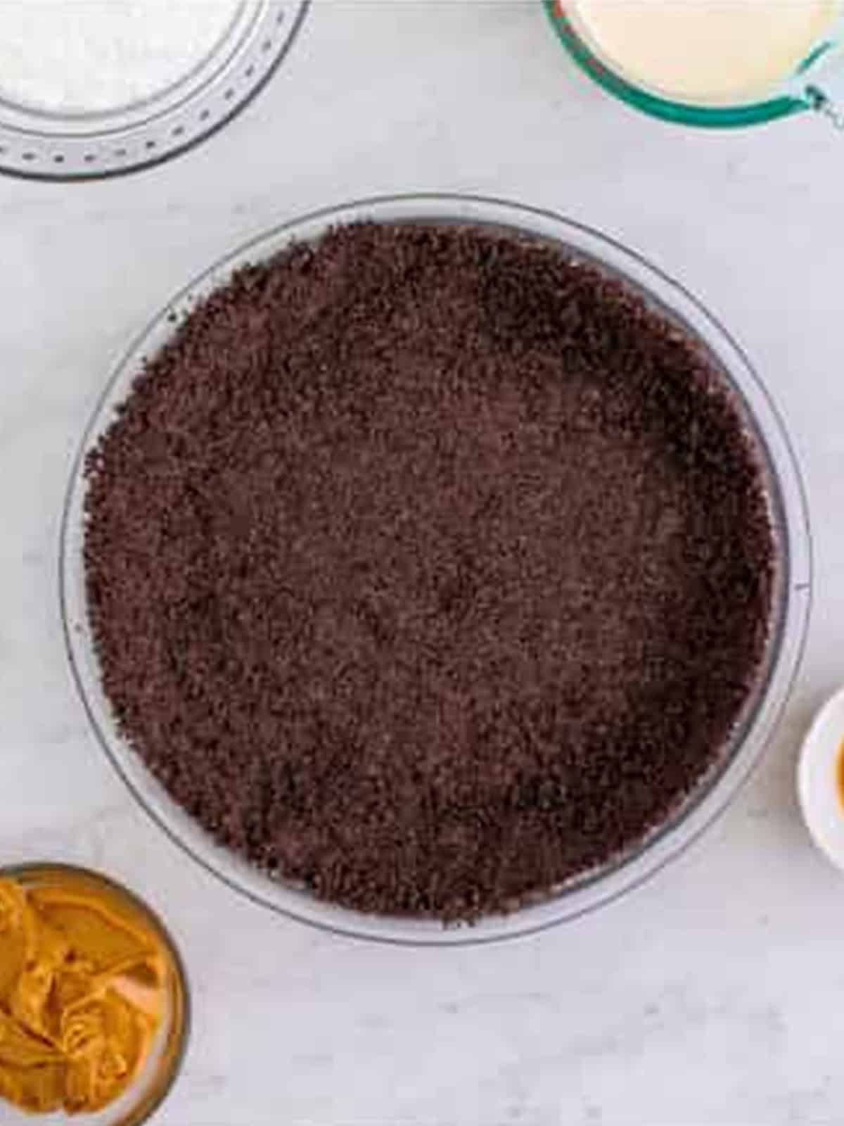 Oreo crumb crust pressed into a springform pan for peanut butter pie.