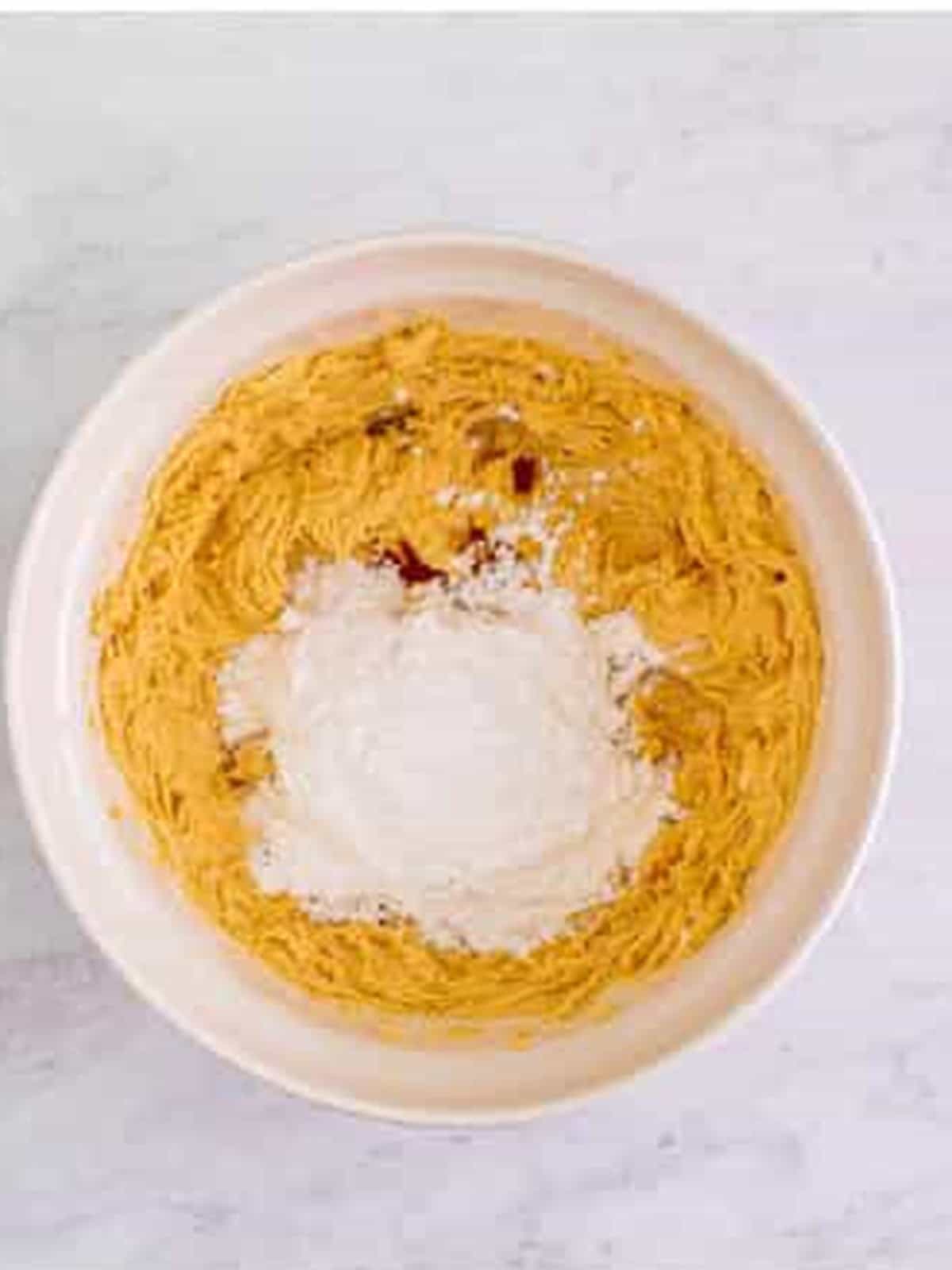 Adding powdered sugar and sweetened condensed milk to the peanut butter filling.