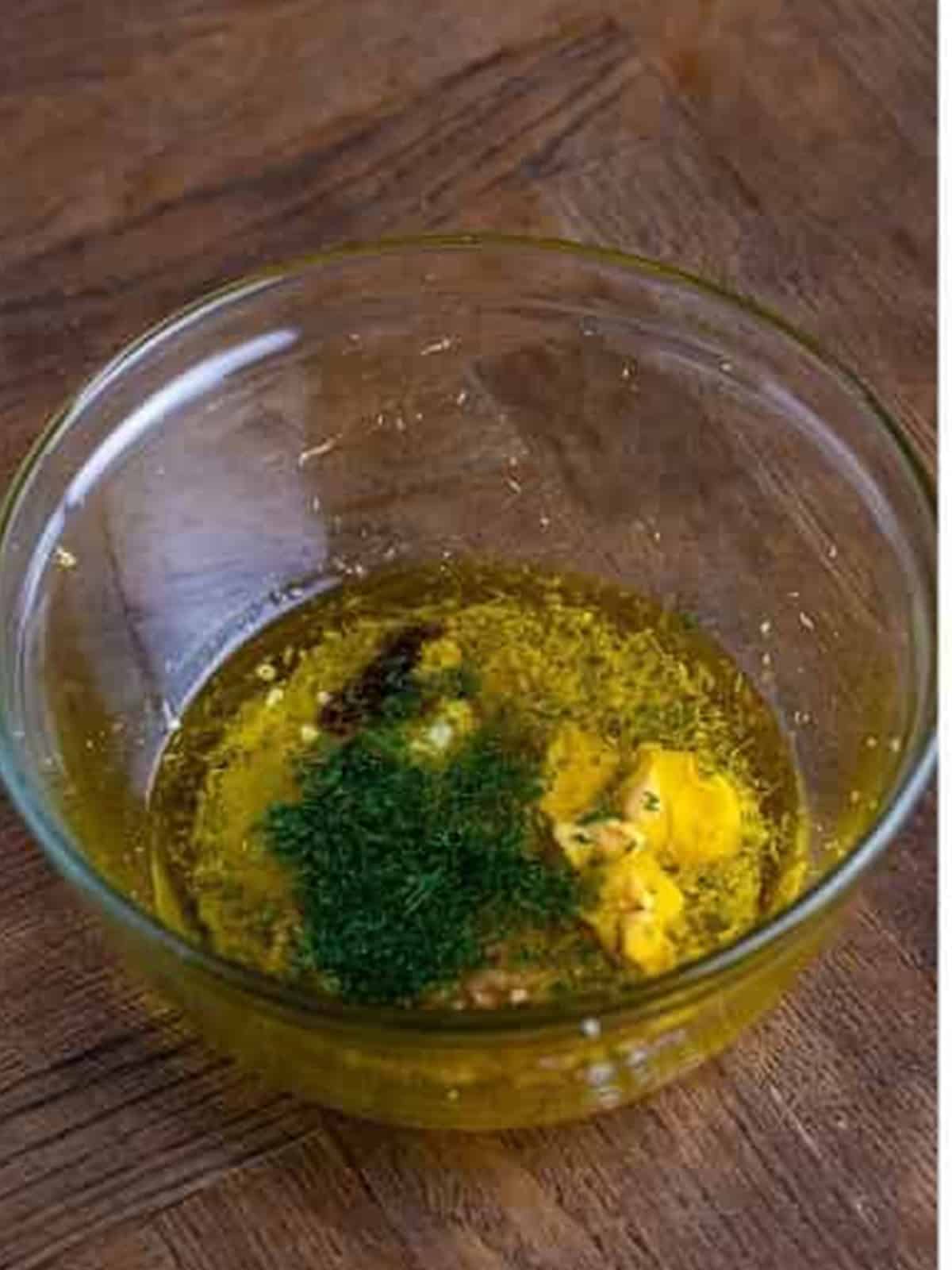 Lemon dill dressing ingredients whisked together in a glass bowl for pearl couscous salad.