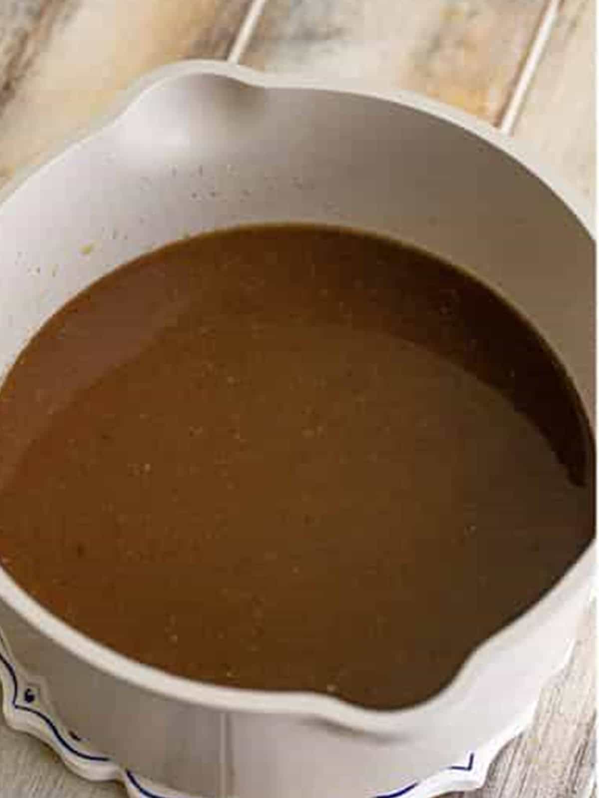 Cooked maple brown sugar syrup base in a saucepan for pecan cobbler.