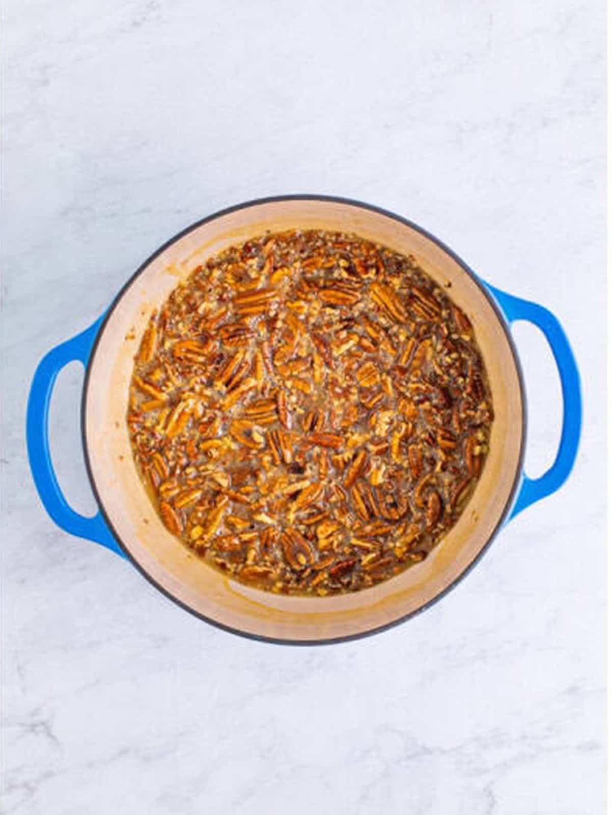 The pecan praline candy mixture brought to a low boil in a pot.