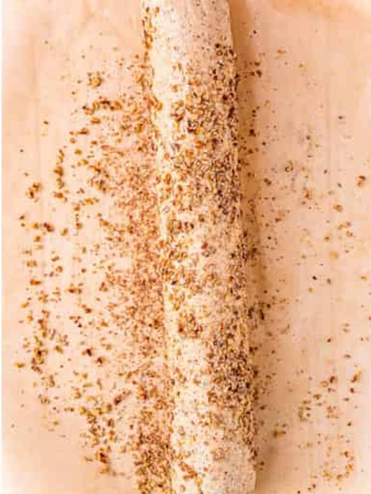 Pecan sandies dough shaped into a log and rolled in chopped pecan pieces.