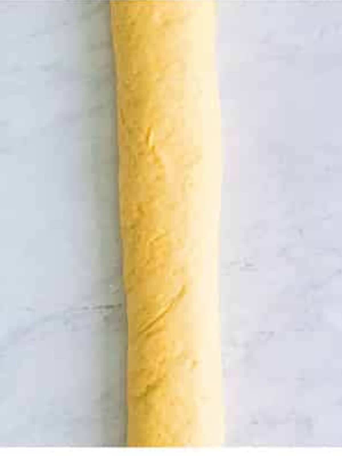 The cinnamon sugar dough rolled into a long log and sliced into buns.