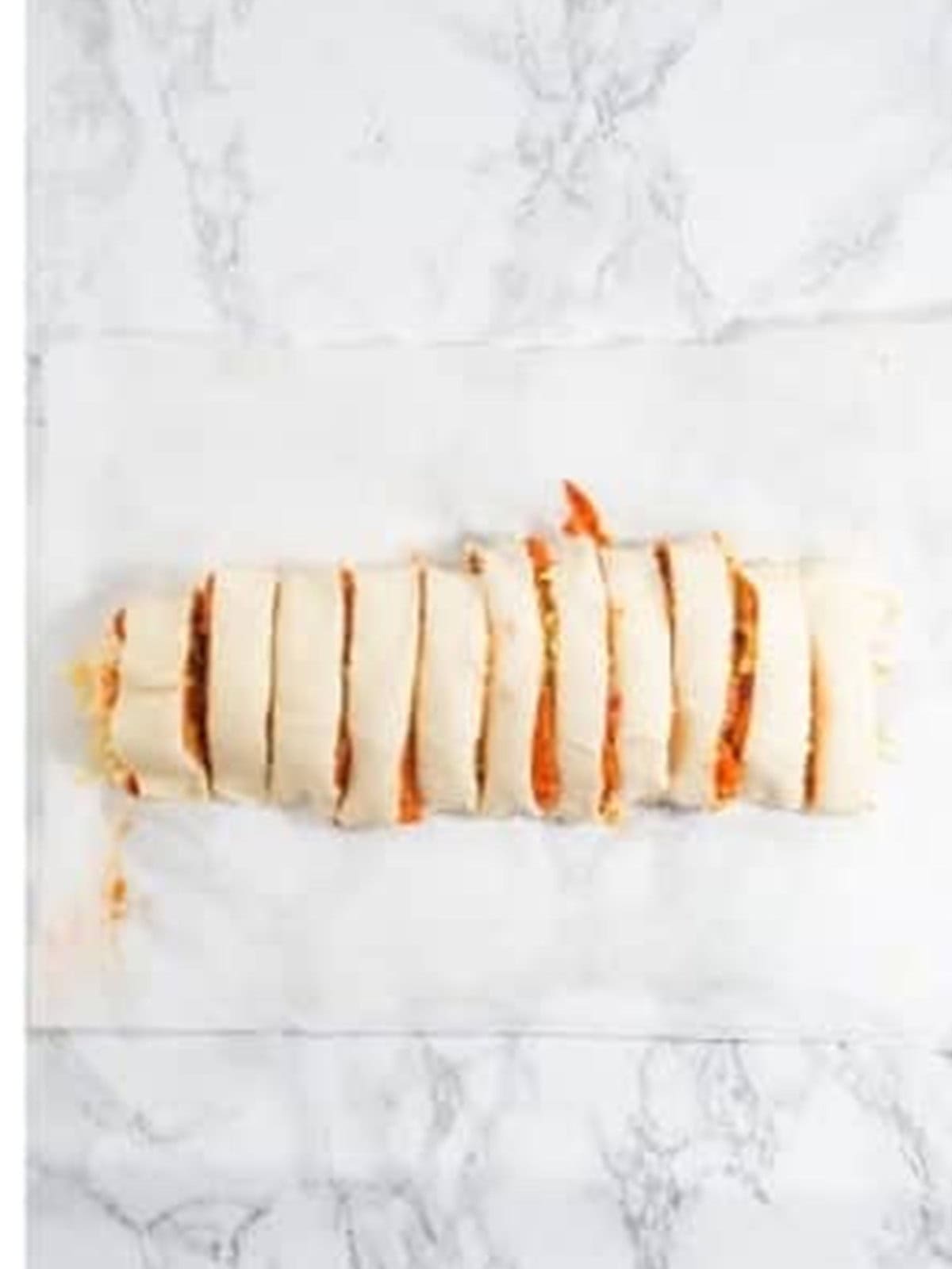 Sliced pepperoni roll pinwheels ready for the baking tray.