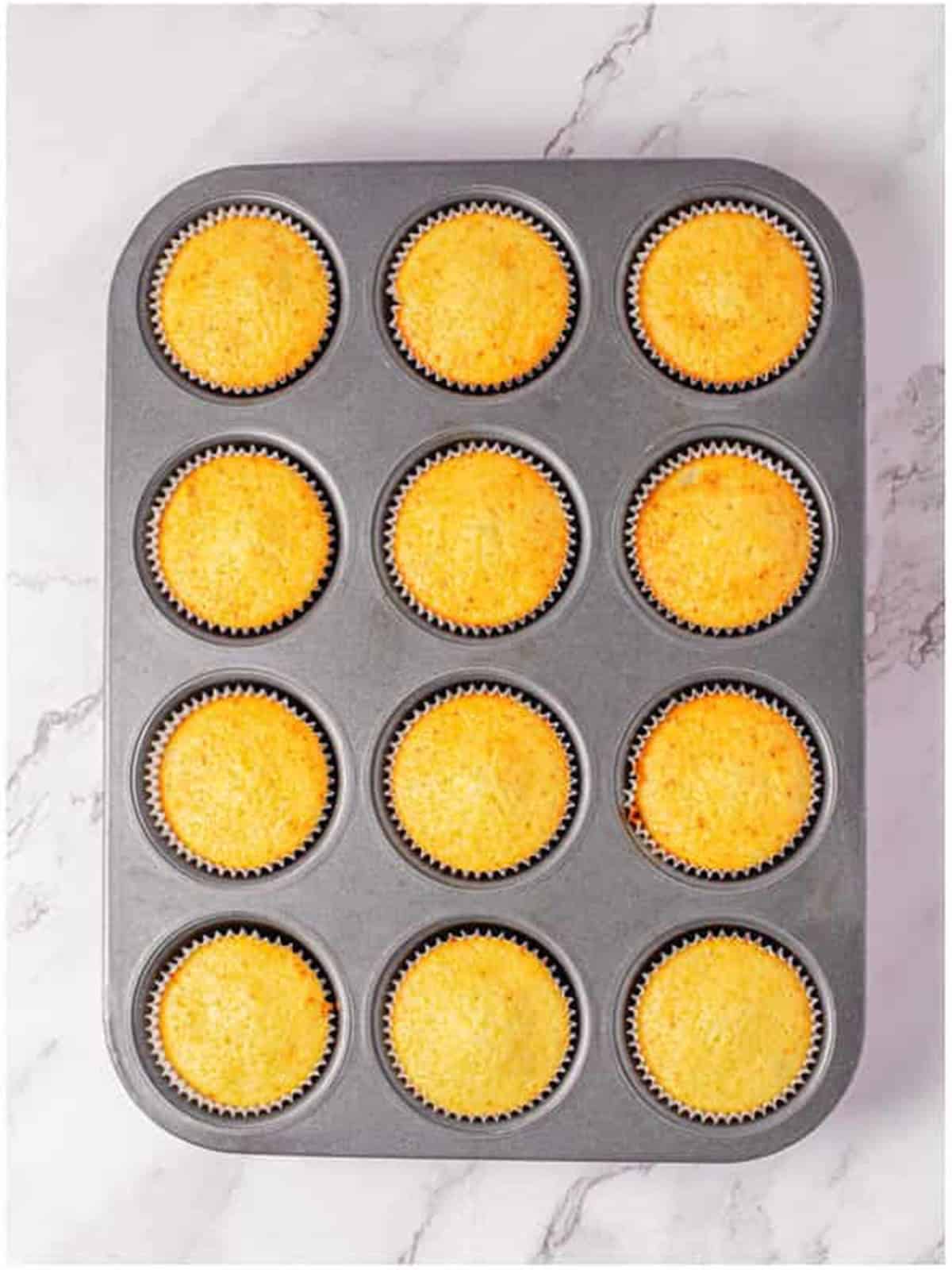 Golden baked pina colada cupcakes in the muffin tin.
