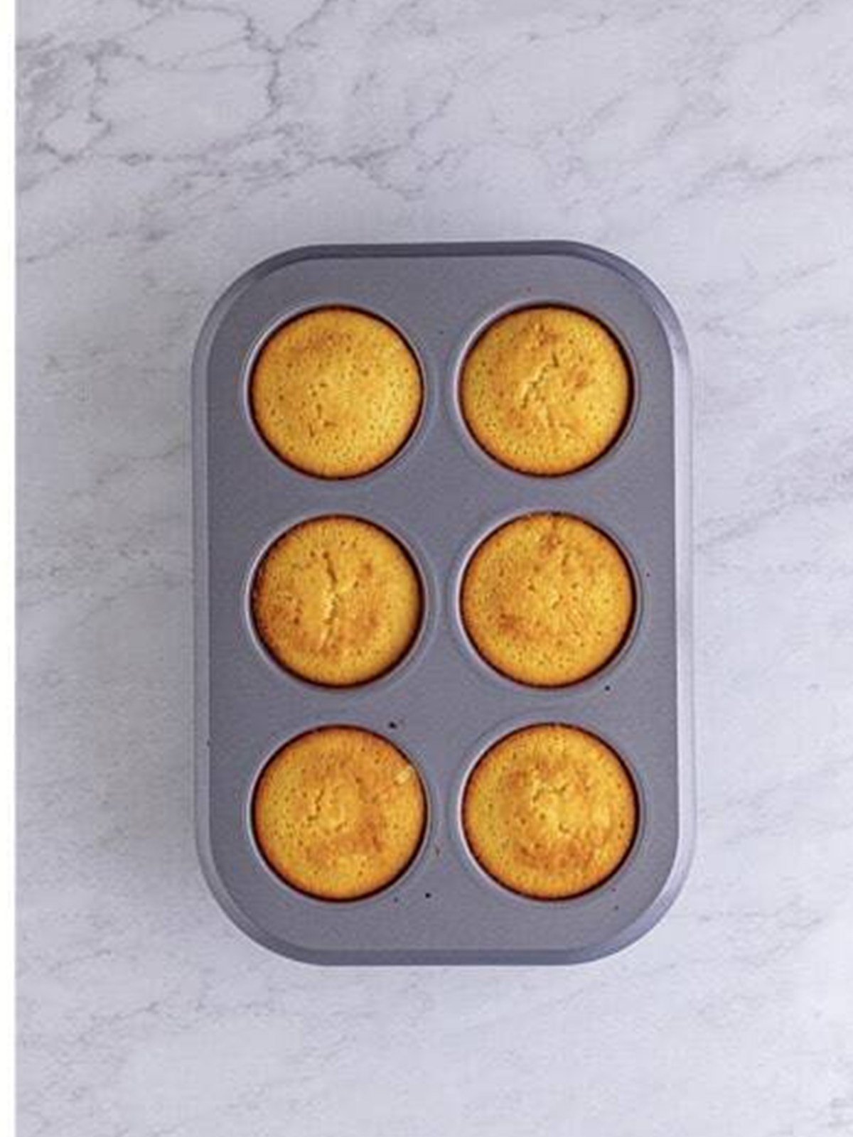 Golden baked Pineapple Upside Down Cupcakes in the muffin tin.