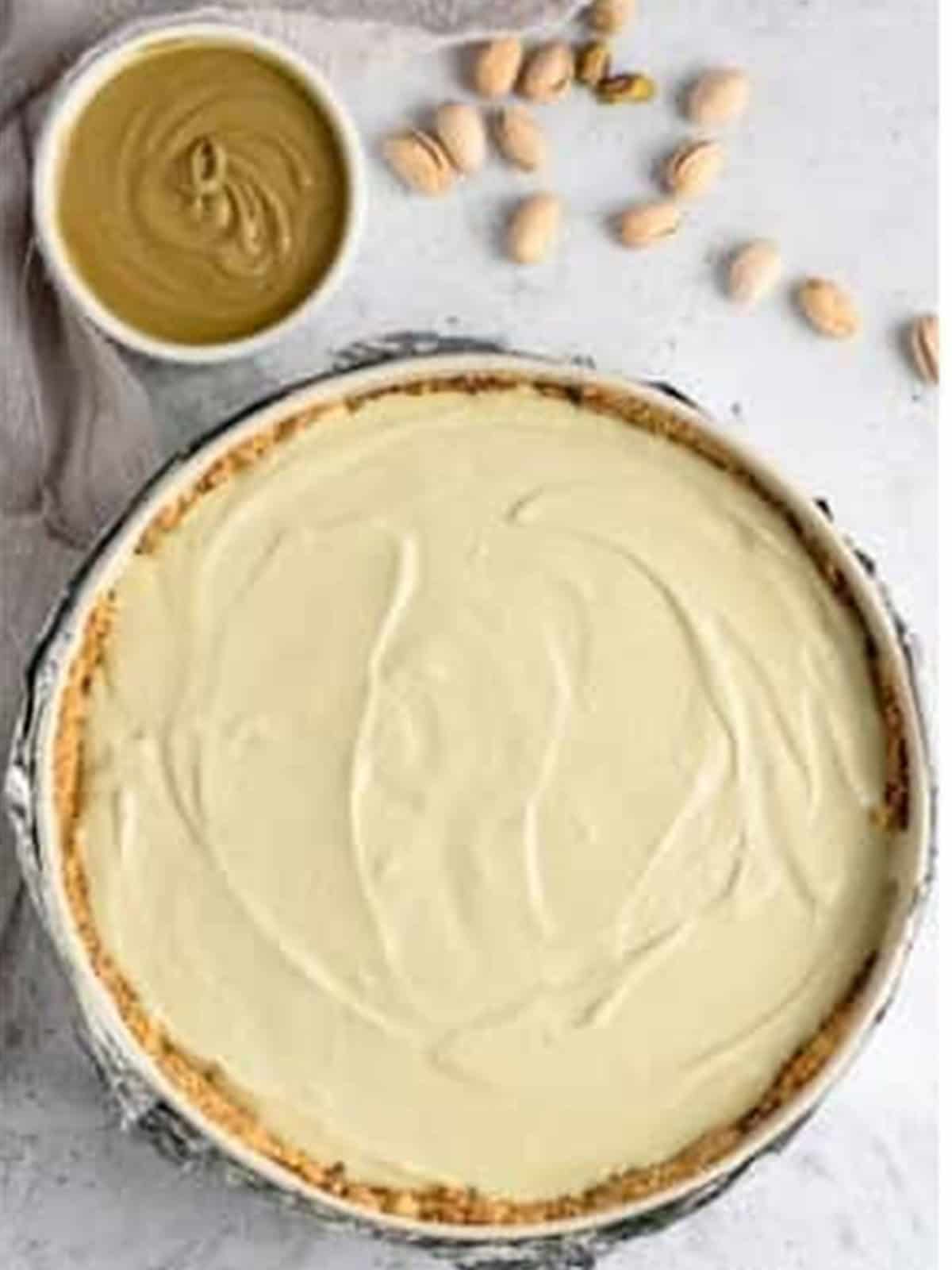 Pistachio cheesecake filling poured over the crust and smoothed.