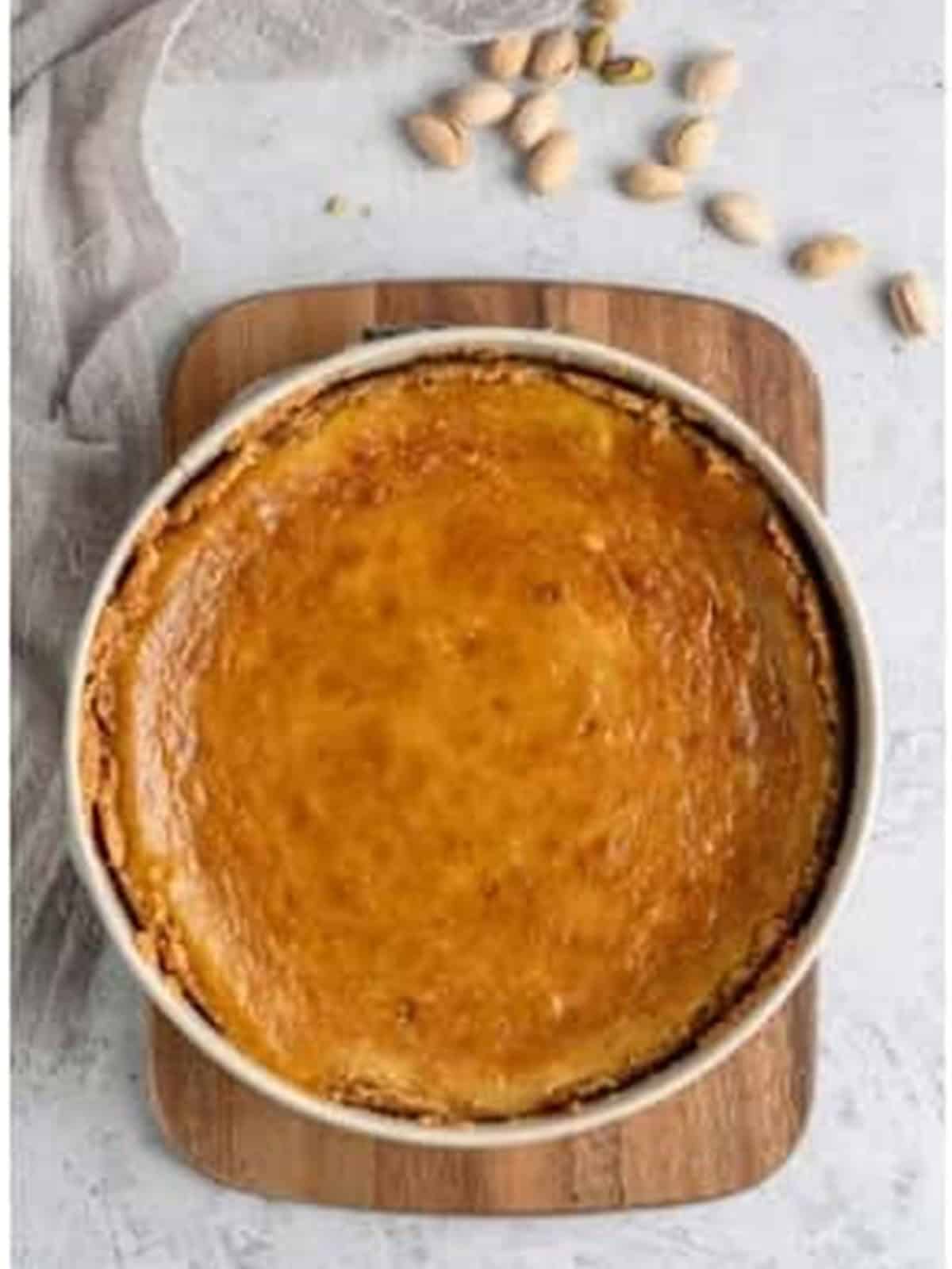 Baked pistachio cheesecake on a wooden board.