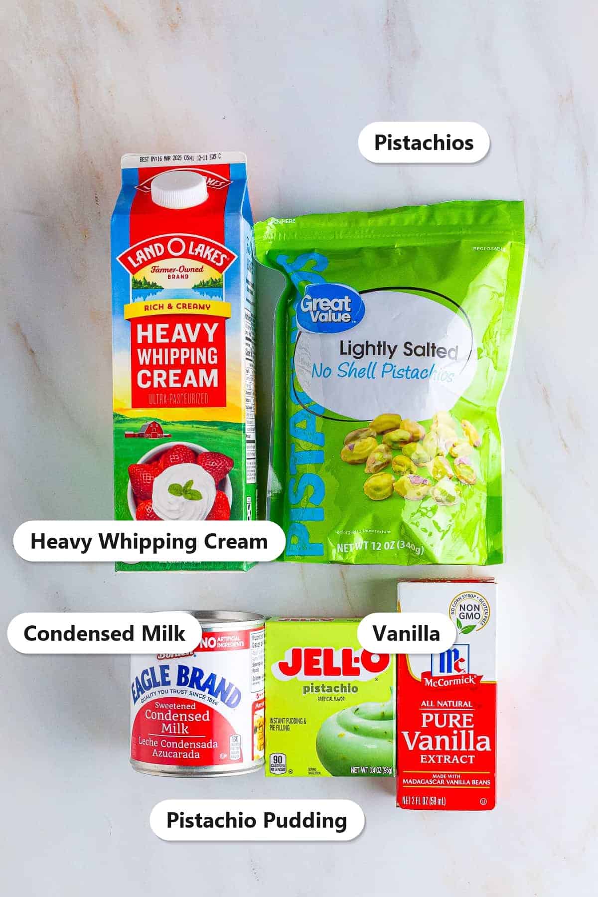 Labeled ingredients for no churn pistachio ice cream including heavy whipping cream, pistachios, condensed milk, pistachio pudding mix, and vanilla.