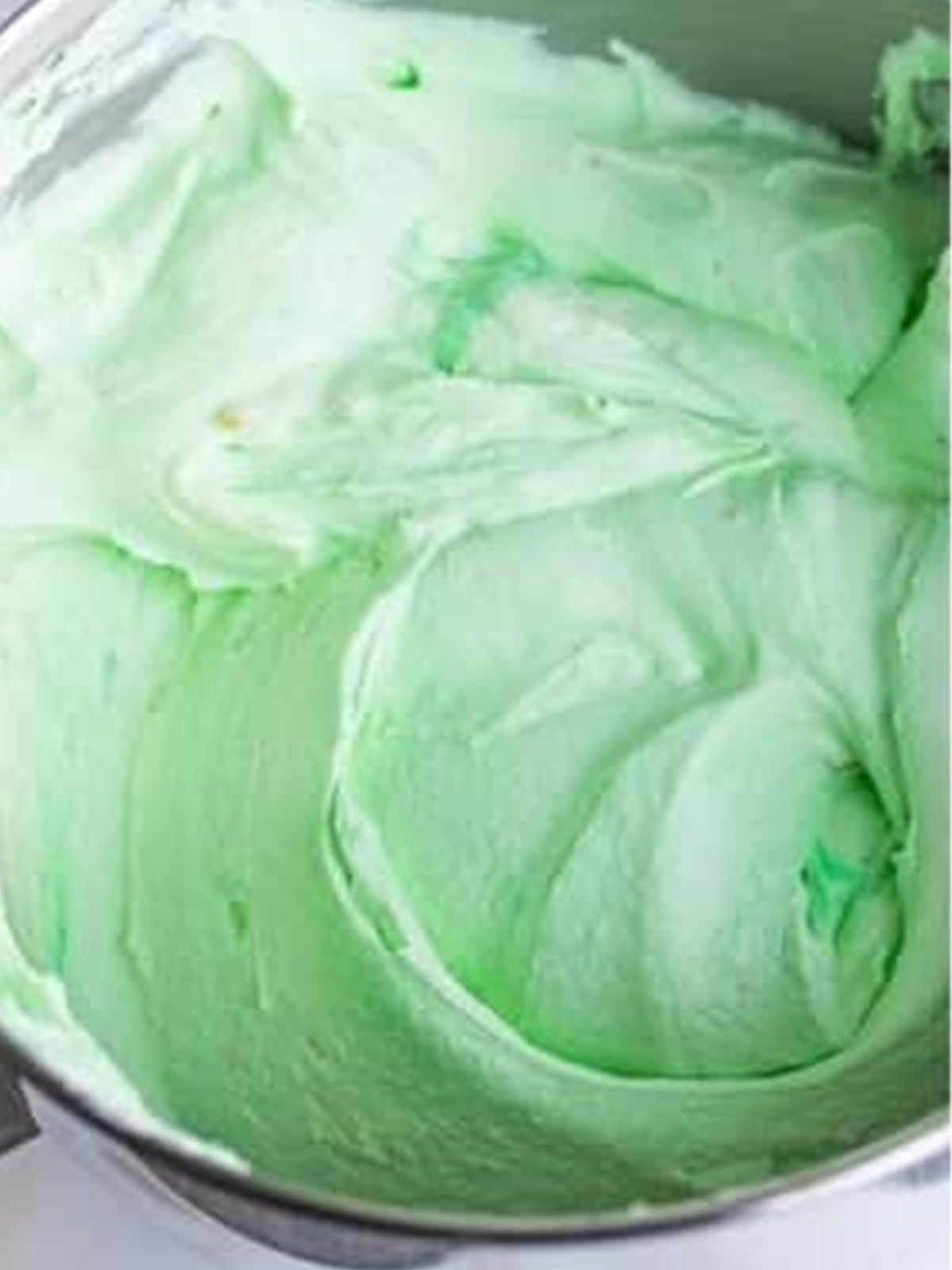 Smooth pale green no churn pistachio ice cream mixture in a bowl.