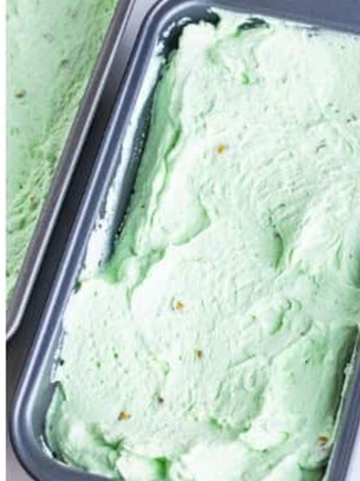 No churn pistachio ice cream spread into a loaf pan before freezing.