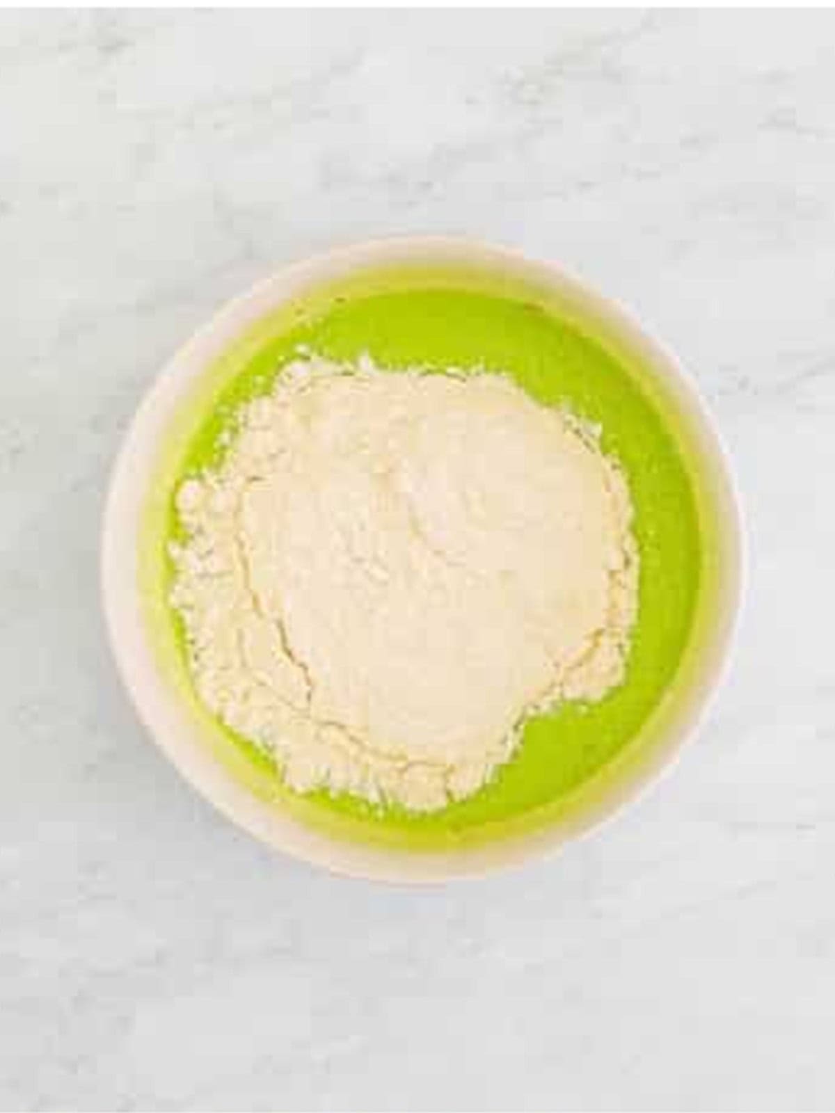 Flour added to the green pistachio muffin batter.