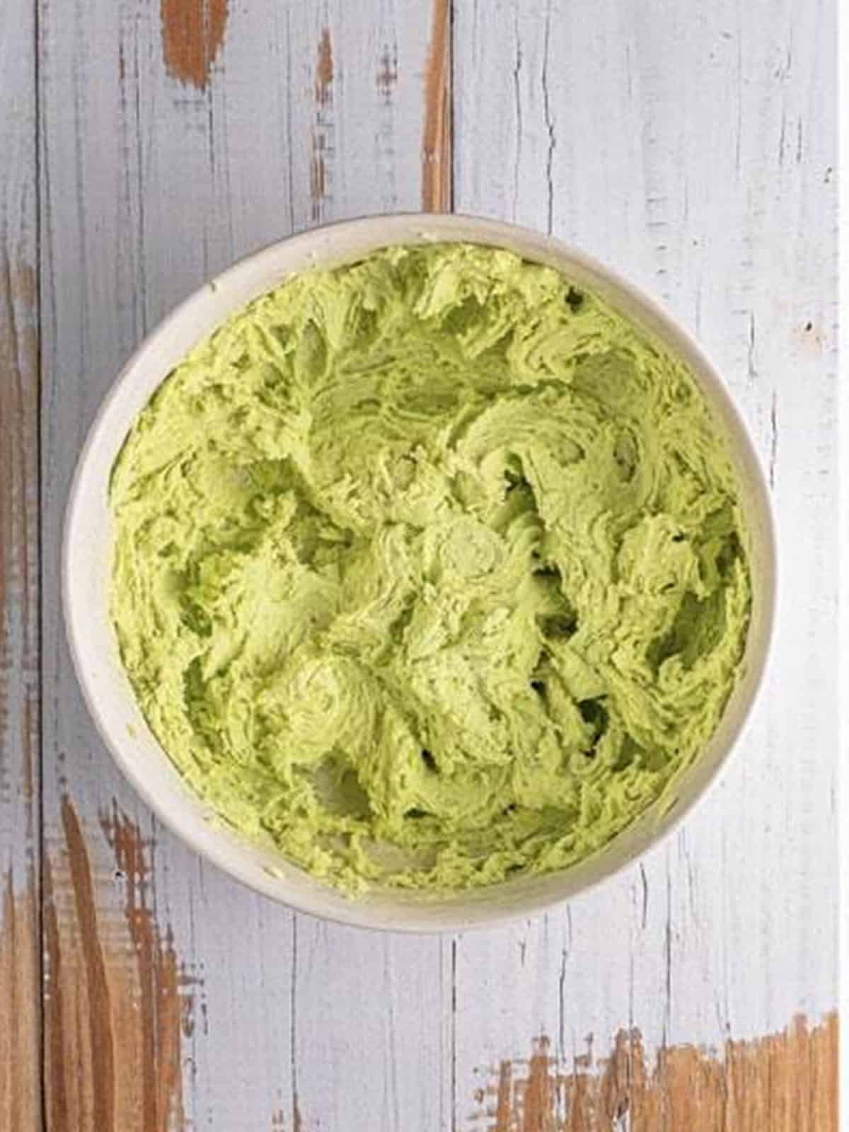 Stirring white chocolate chips and chopped pistachios into the green cookie dough.