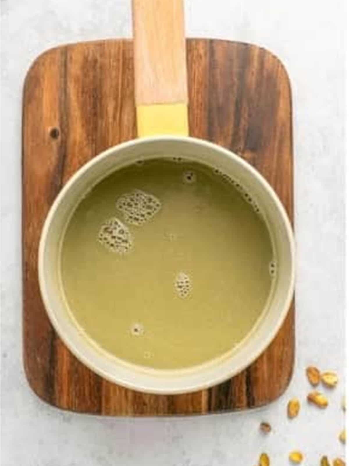 Warming the milk, cream, and pistachio spread until smooth in the saucepan.