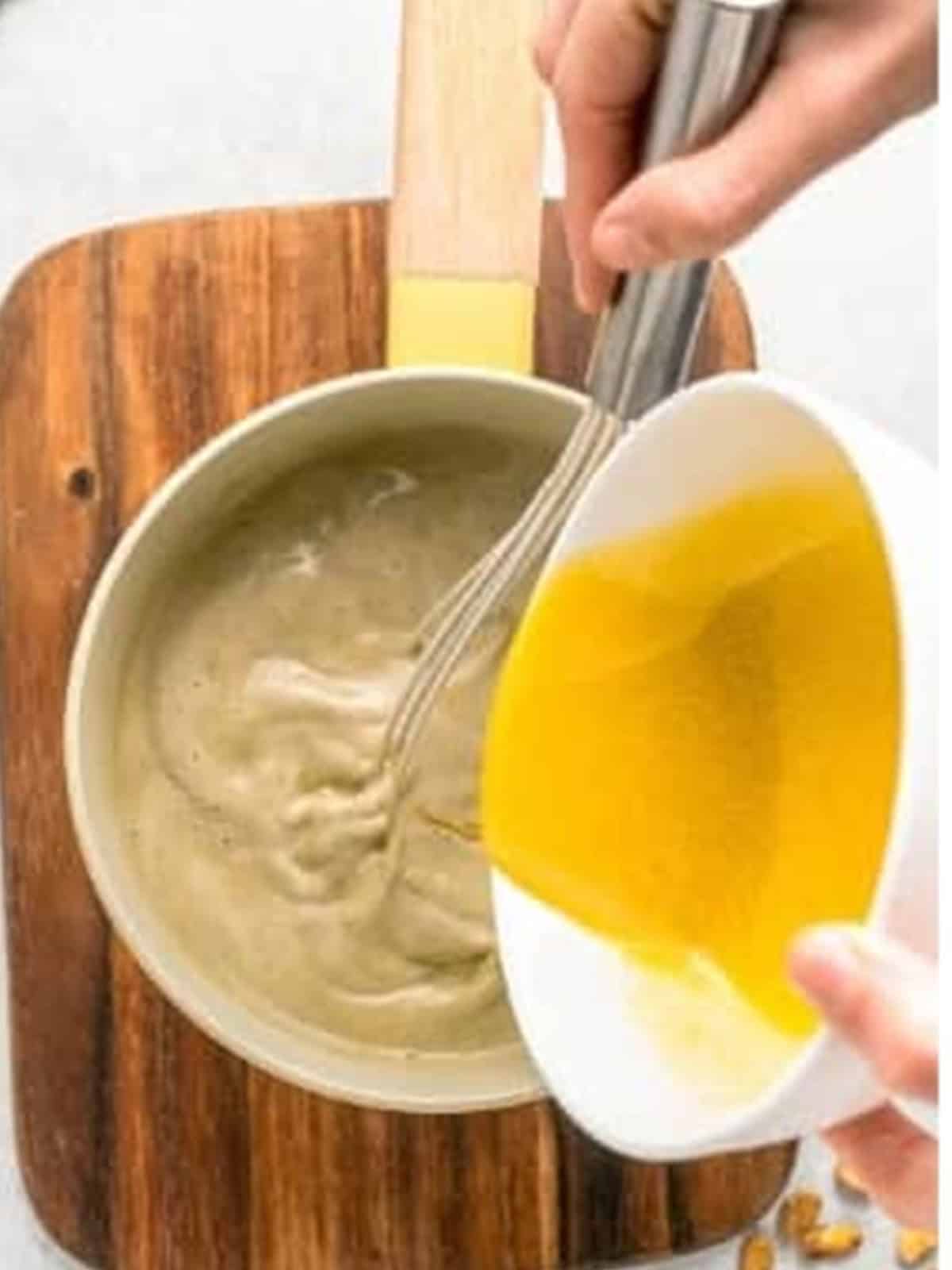 Tempering the egg yolks into the warm pistachio milk while whisking.