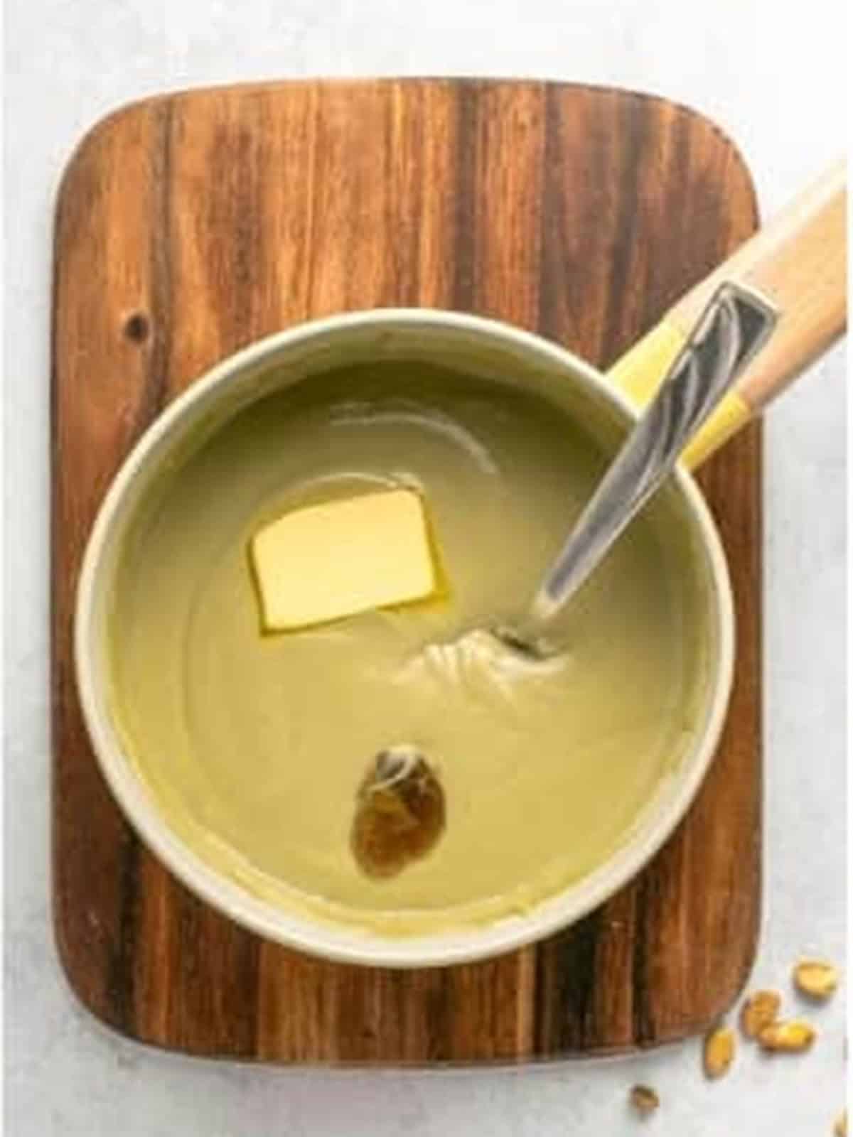 Stirring butter and vanilla into the thickened pistachio pudding.