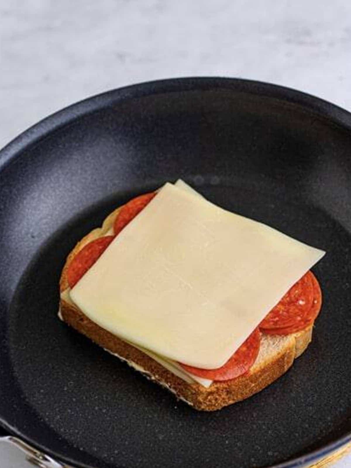 Adding more mozzarella and pepperoni to the Pizza Sandwich.